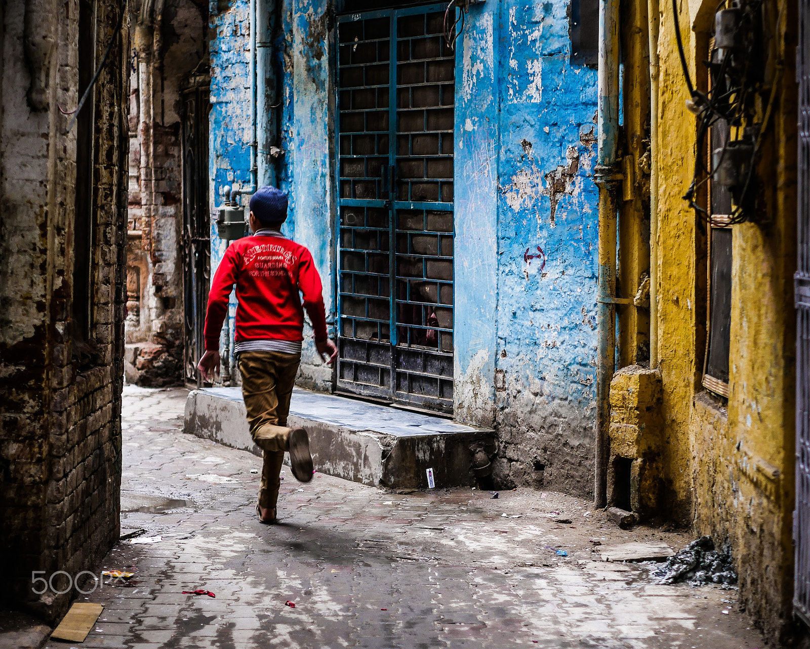 Panasonic Lumix DMC-GH4 + Olympus M.Zuiko Digital 45mm F1.8 sample photo. Boy running through alleyway photography