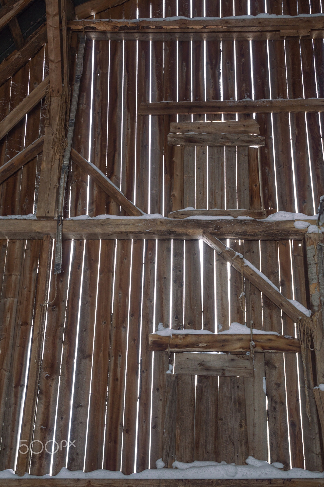 Nikon D3200 sample photo. Inside of an old barn with beams and boards and snow photography
