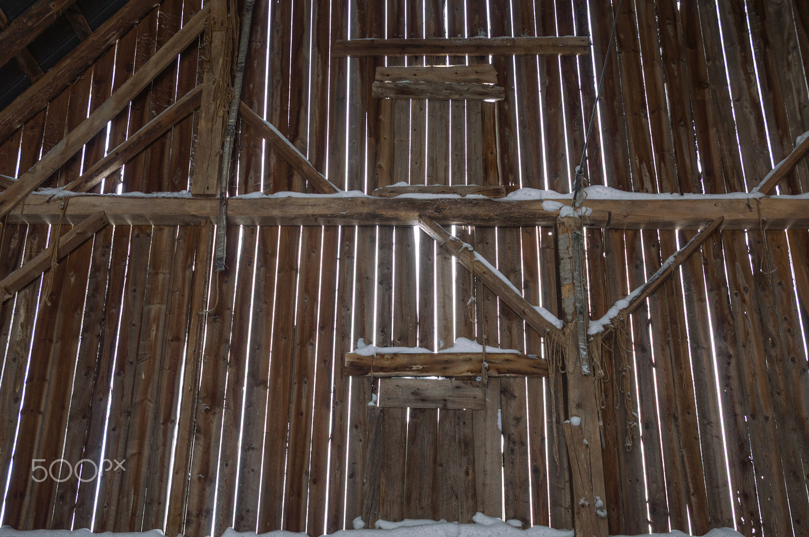 Nikon D3200 sample photo. Inside of an old barn with beams and vertical boards and snow photography