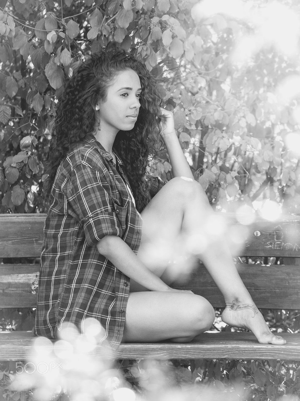 Panasonic Lumix DMC-GH3 sample photo. Monochrome hispanic woman sitting on a bench in a park photography
