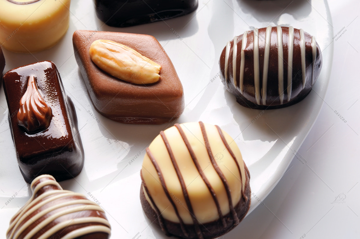 Nikon D300 sample photo. Assorted bonbons on a white plate top view close up photography