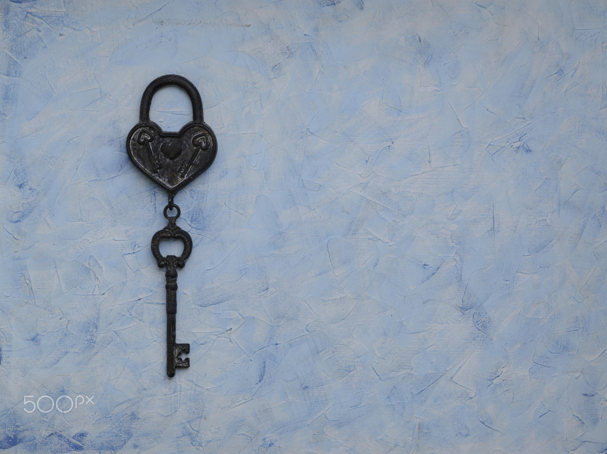 iron key from the lock lying on wooden vintage background, top view