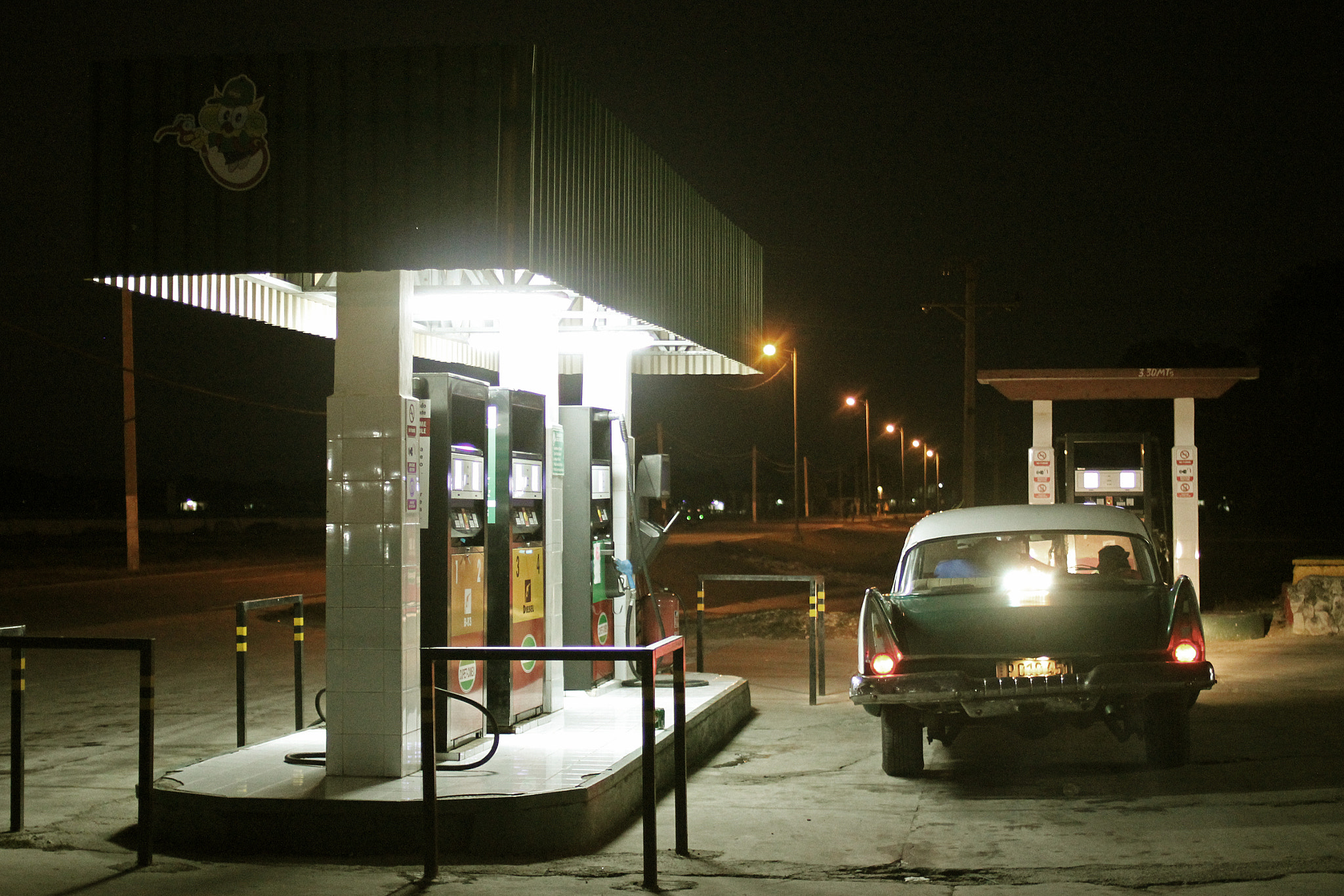 Canon EOS 600D (Rebel EOS T3i / EOS Kiss X5) + Canon EF 35mm F2 sample photo. Night in a cuban gas station photography