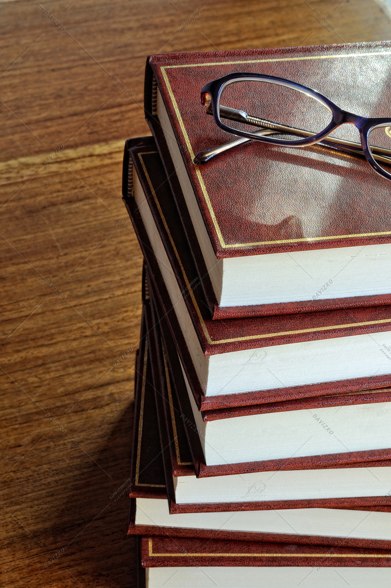 Tamron SP 24-70mm F2.8 Di VC USD sample photo. Stack of books and glasses on tablel horizontal image photography