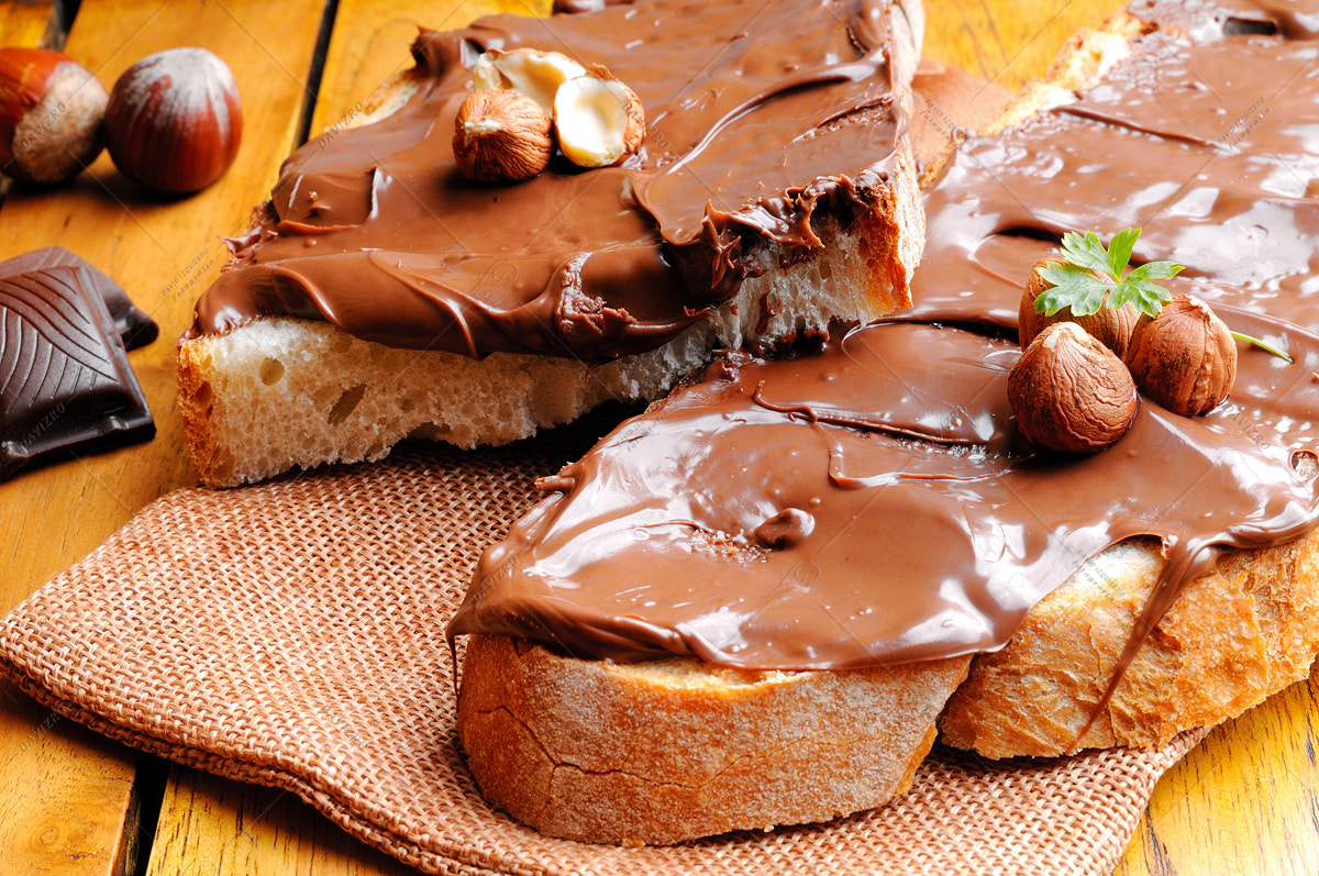 Nikon D300 sample photo. Bread with chocolate cream and hazelnuts on a wooden table photography