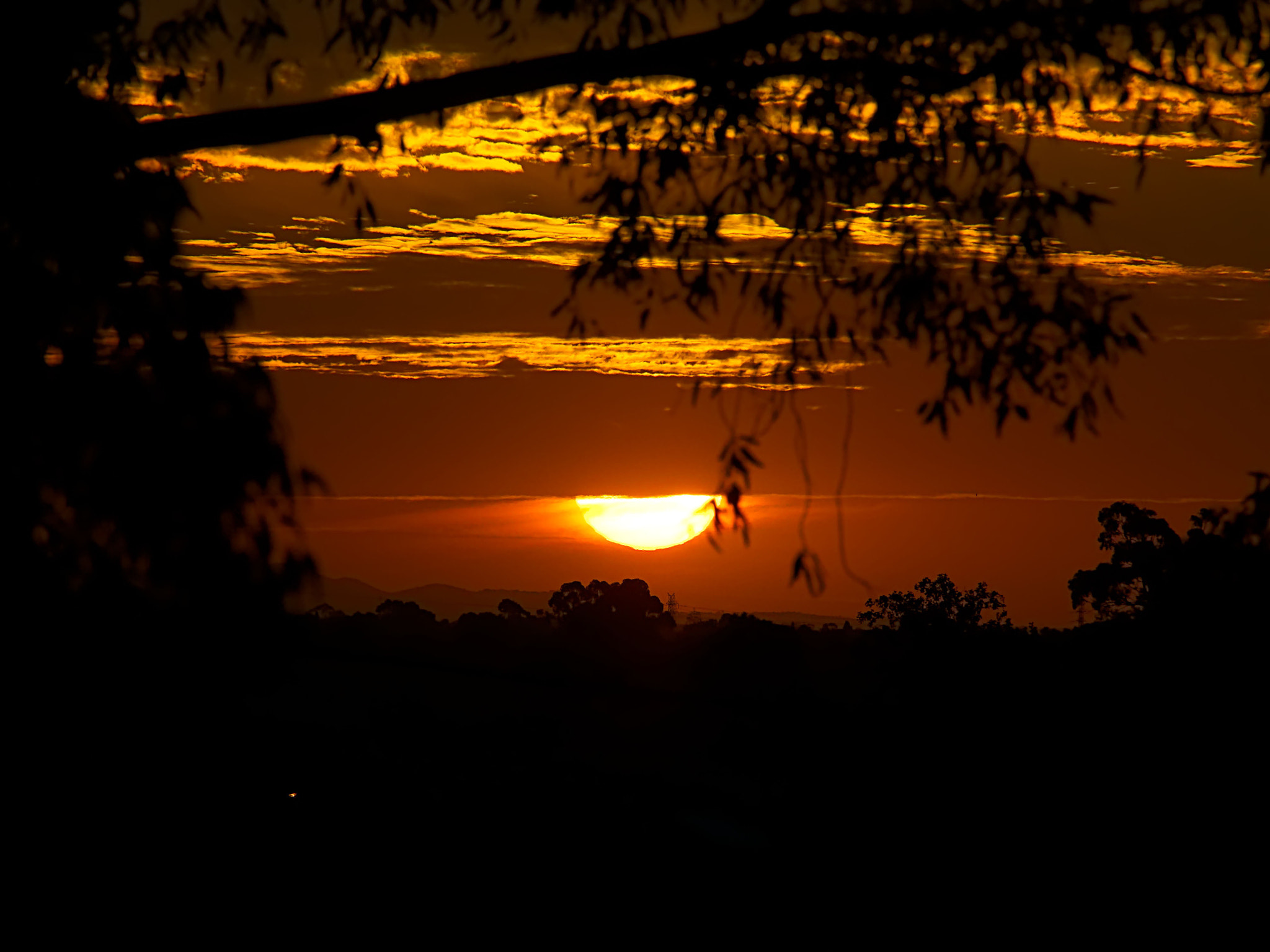 Olympus OM-D E-M10 + Olympus M.Zuiko Digital ED 40-150mm F2.8 Pro sample photo. The setting sun peaking out under the clouds. photography