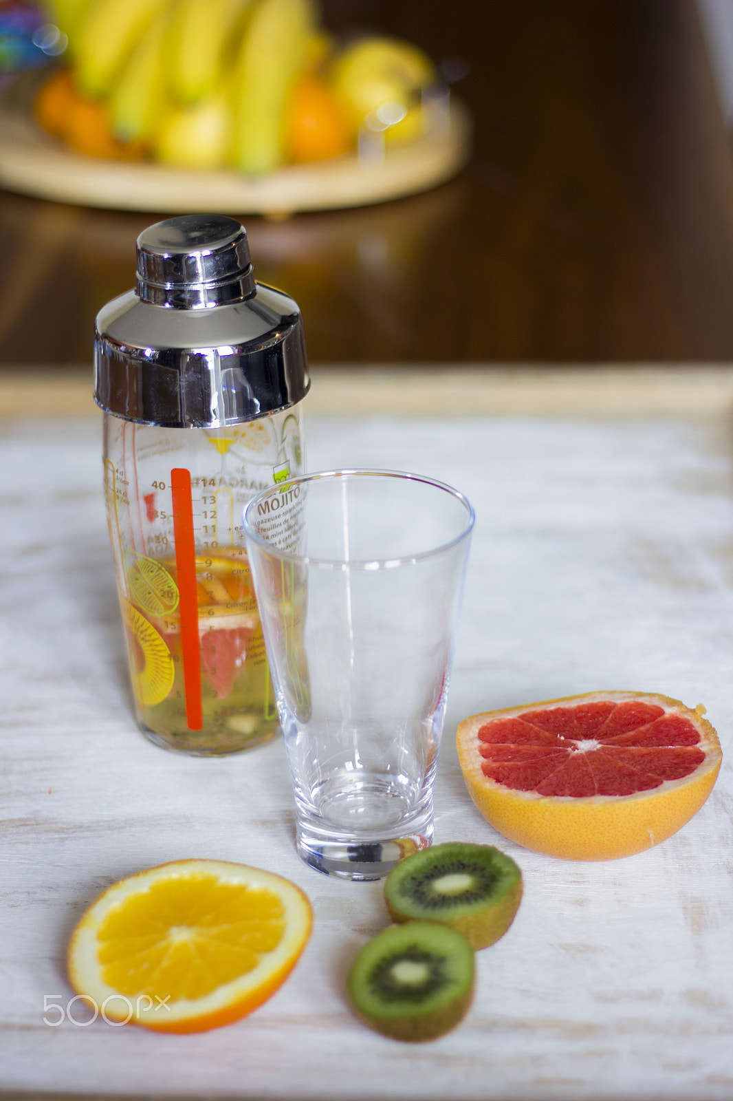 Canon EOS 550D (EOS Rebel T2i / EOS Kiss X4) sample photo. Kiwis, grey fruits and oranges together with a shaker and a glass on a dark lit background. photography