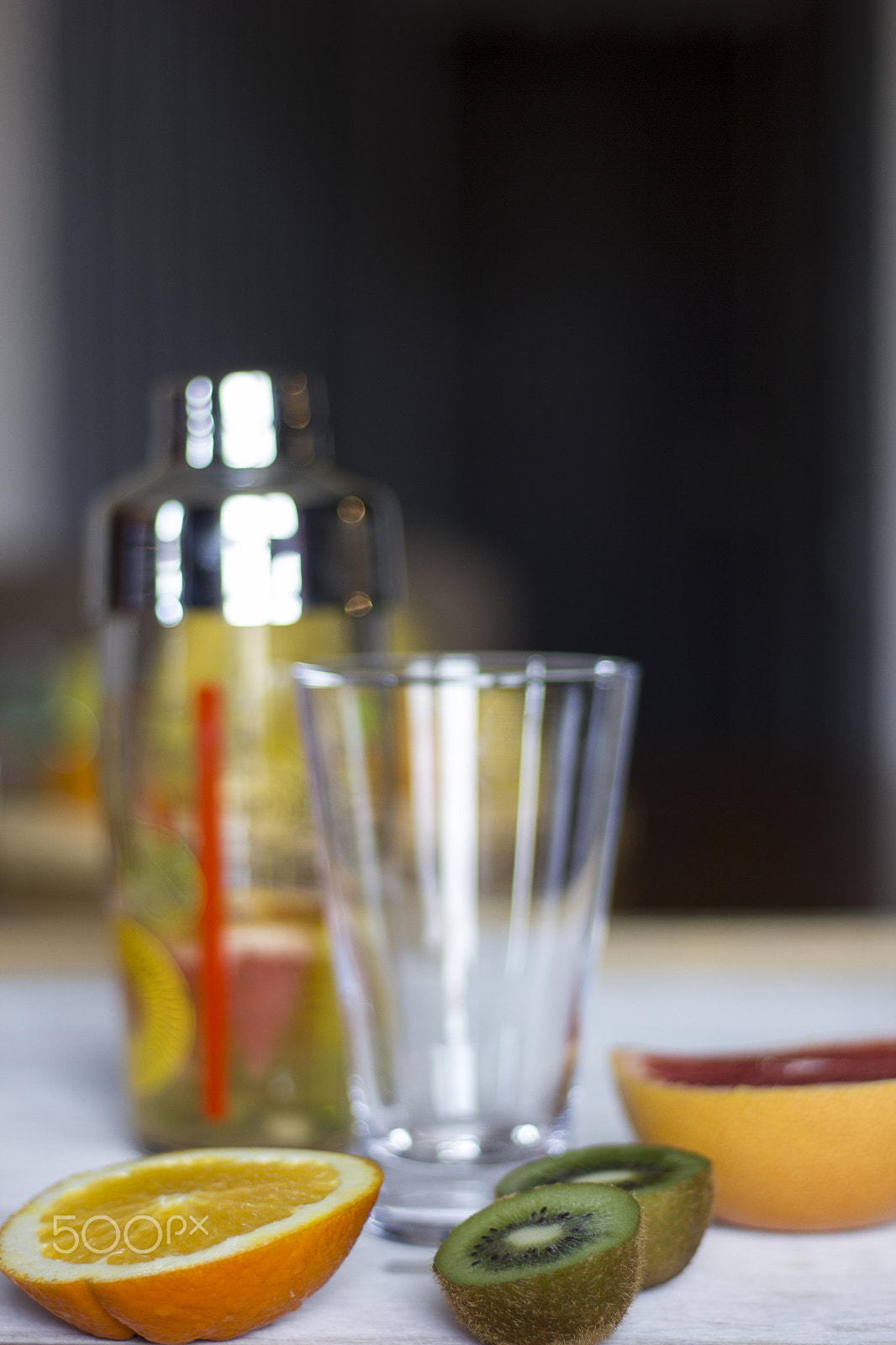 Canon EOS 550D (EOS Rebel T2i / EOS Kiss X4) sample photo. Kiwis, grey fruits and oranges together with a shaker and a glass on a dark lit background. photography