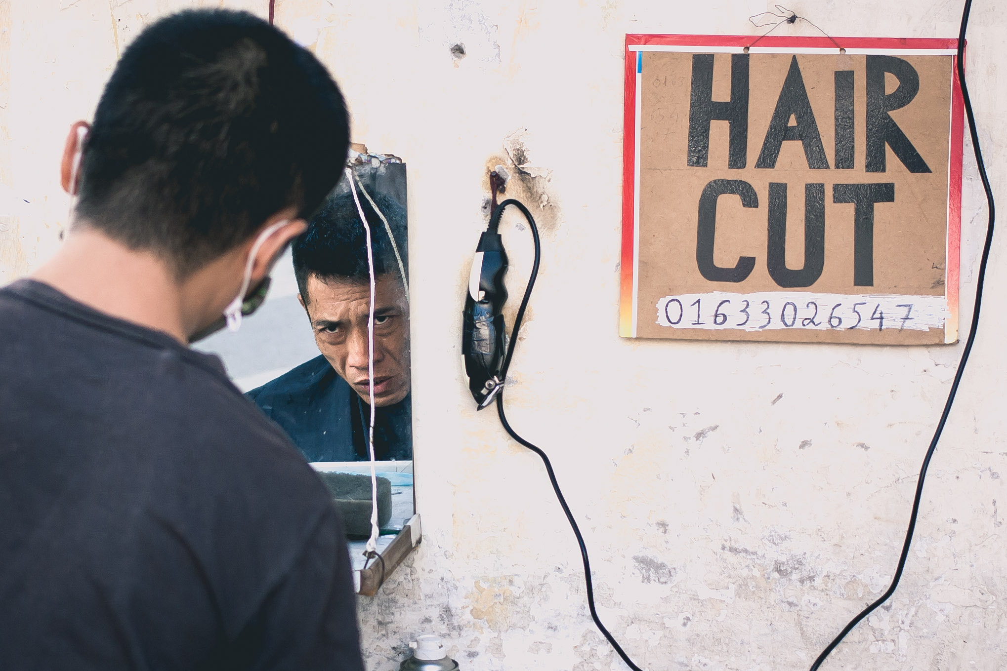 Canon EOS 1000D (EOS Digital Rebel XS / EOS Kiss F) + Canon EF 40mm F2.8 STM sample photo. Street barber at work in hanoi photography