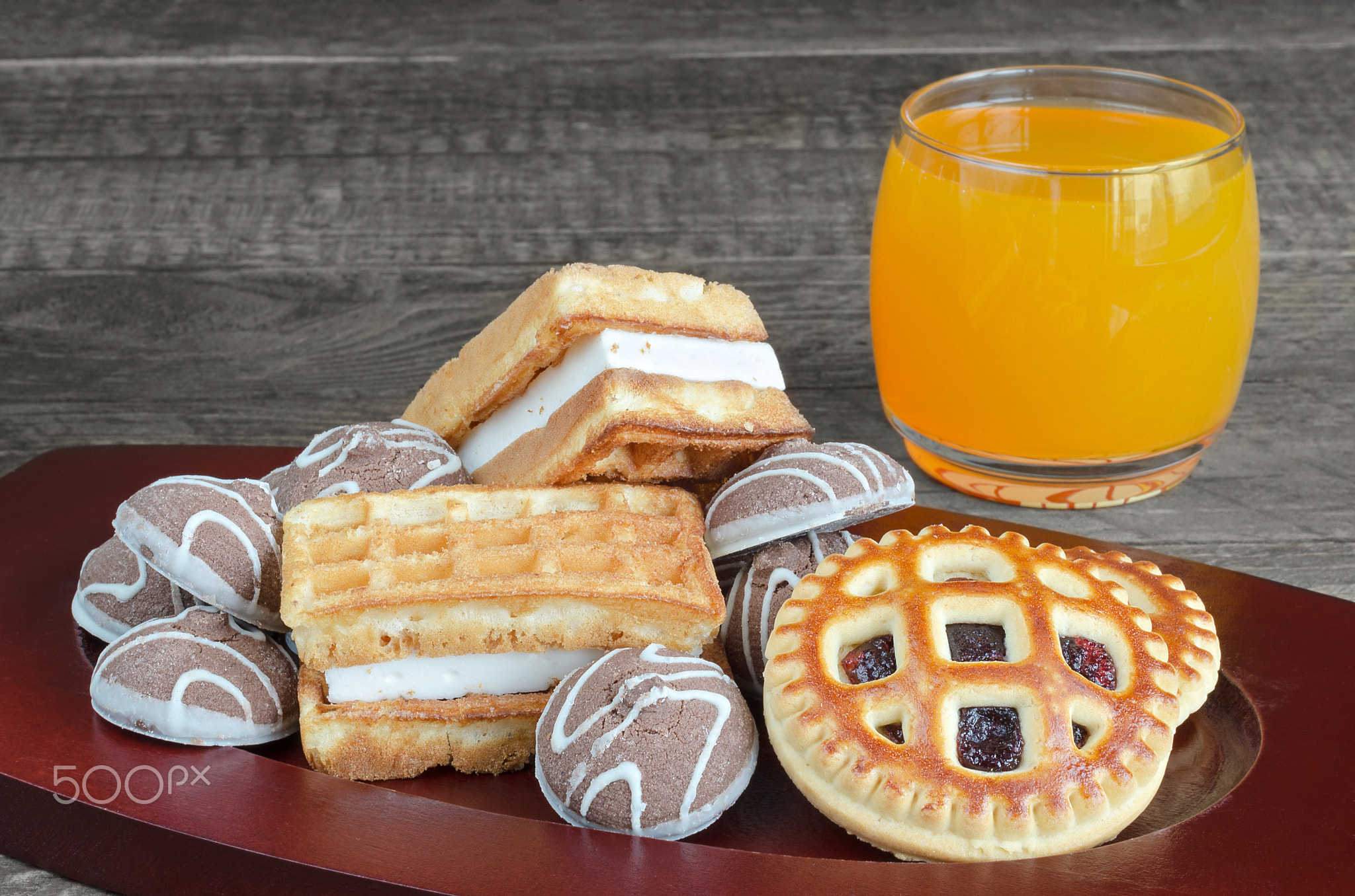 Different cookies and juice on wooden background. Selective focus.