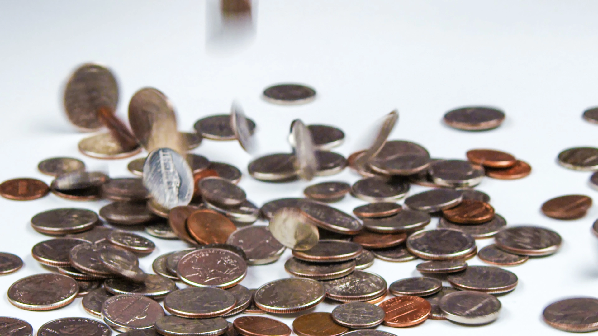 Coins dropping onto a surface.