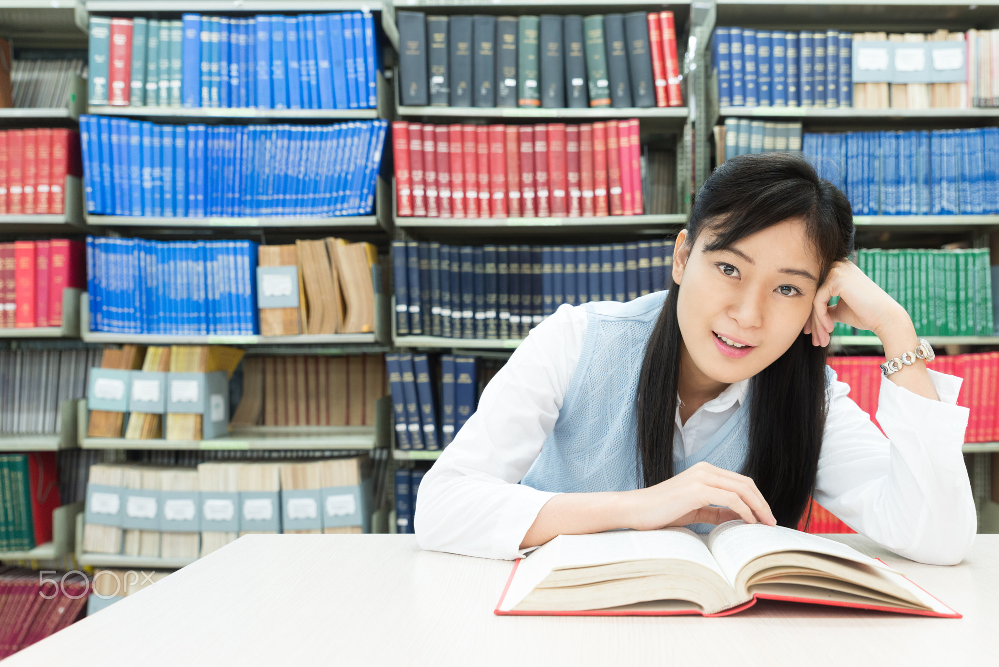 Asian student reading book in library at university.