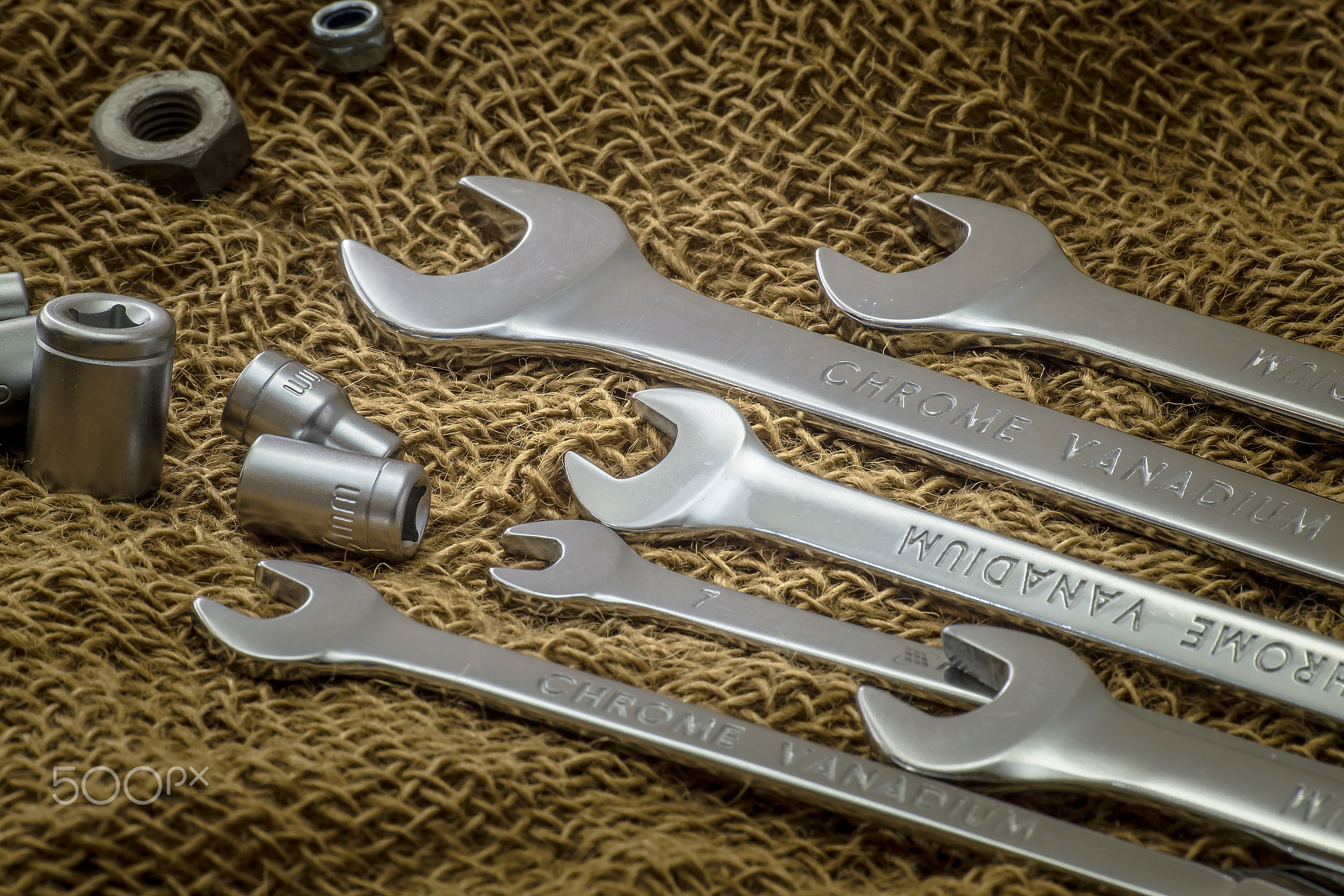 Wrenches closeup on a rough cloth. Brown background. Side view.