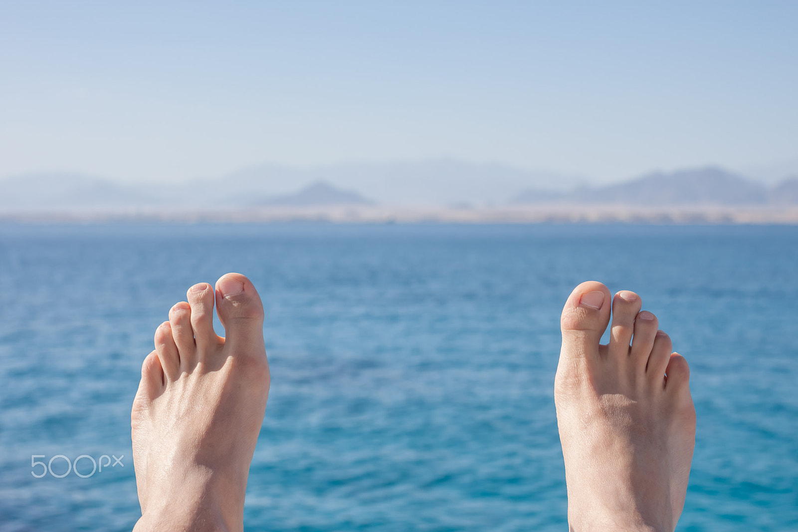 Canon EOS 500D (EOS Rebel T1i / EOS Kiss X3) sample photo. Man feet on sea and mountains background photography