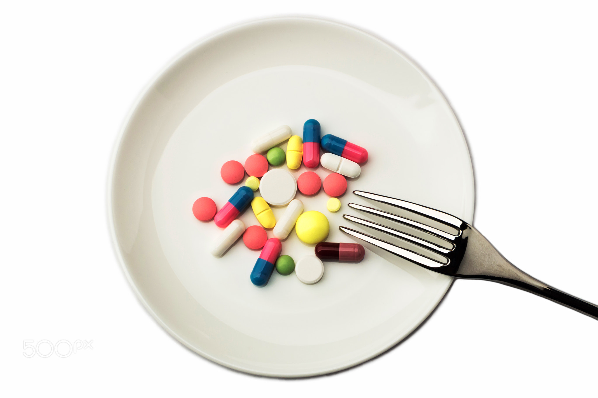 Pills on white plate with fork. Pill instead of food