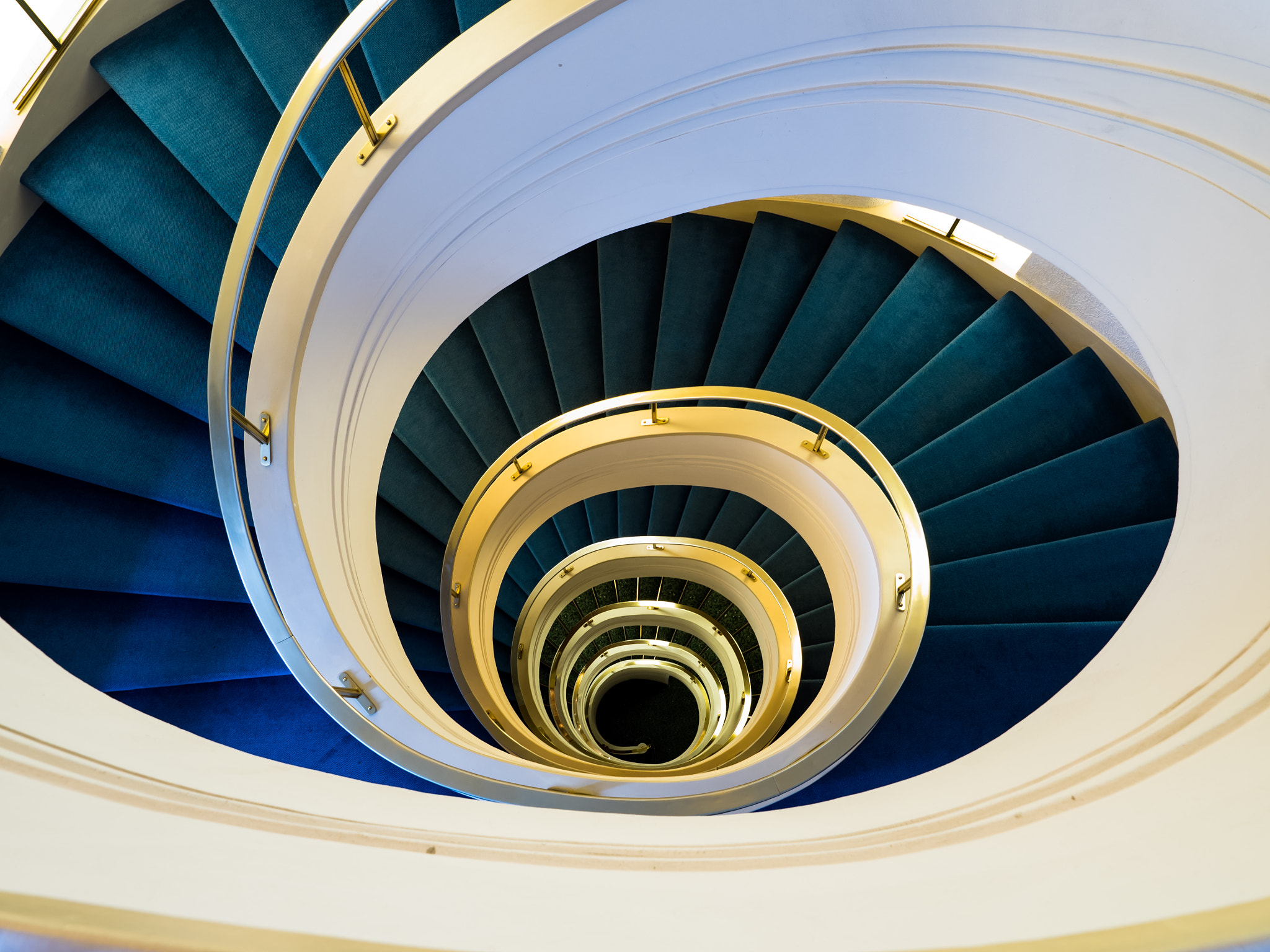 Olympus OM-D E-M5 II + Olympus M.Zuiko Digital ED 7-14mm F2.8 PRO sample photo. Staircase with a golden  handrail  and a blue carpet photography