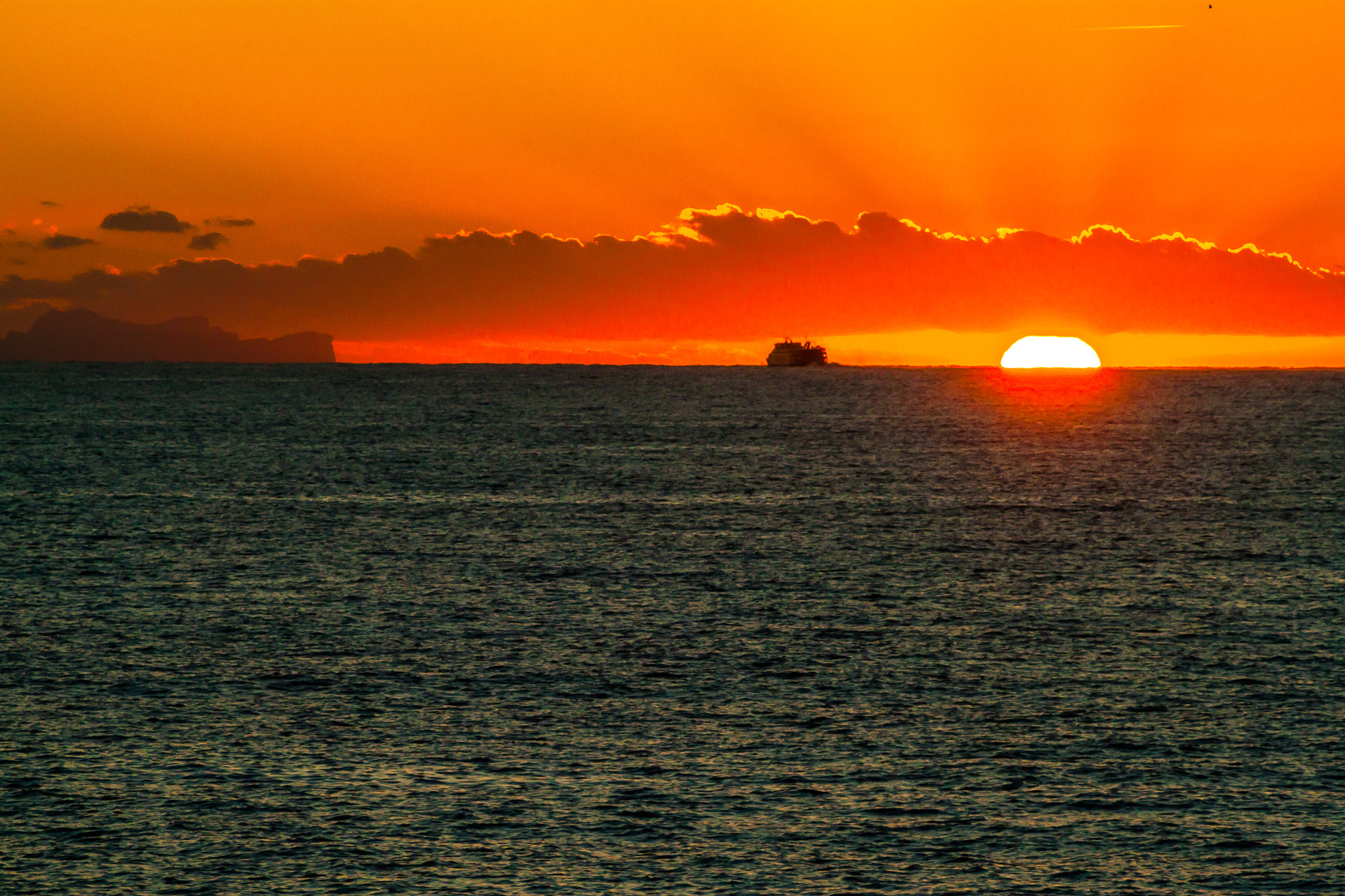 Canon EOS 500D (EOS Rebel T1i / EOS Kiss X3) + EF75-300mm f/4-5.6 sample photo. Sun setting below cloud as ferry heads away photography