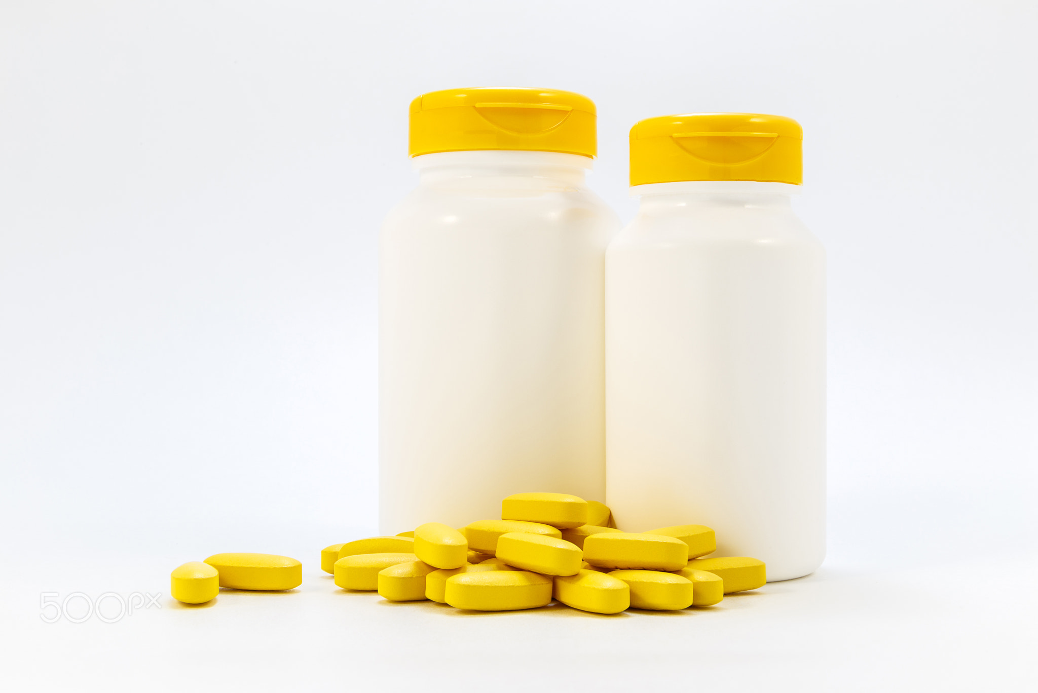 Jars of medicines under the pills lying on a white background