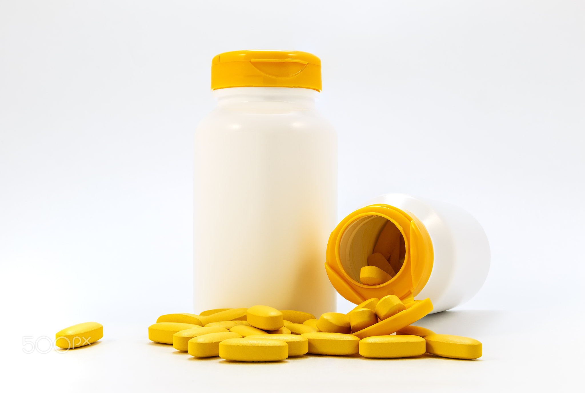Jars of medicines under the pills lying on a white background