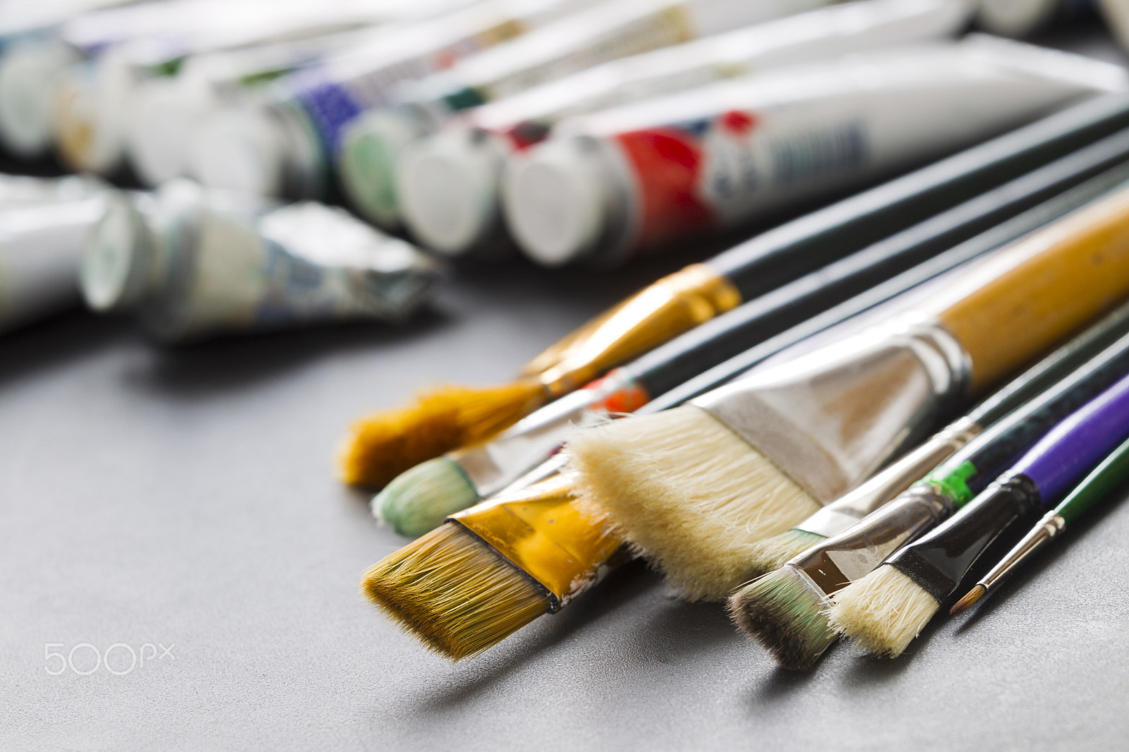 Canon EOS-1D Mark IV sample photo. Paint brushes on the background of tubes of paint photography