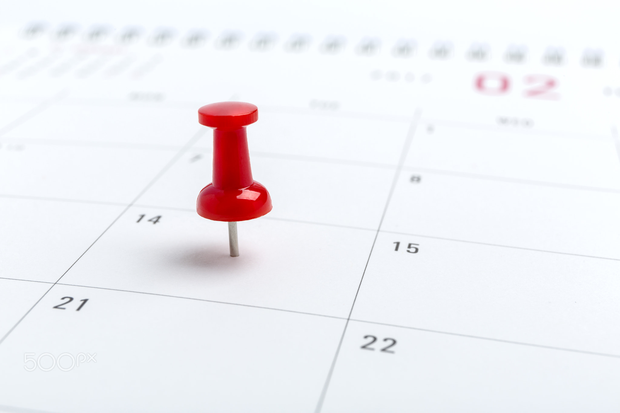 Concept image of a Calendar with red push pin. Closeup shot thumbtack attached. The words heart...