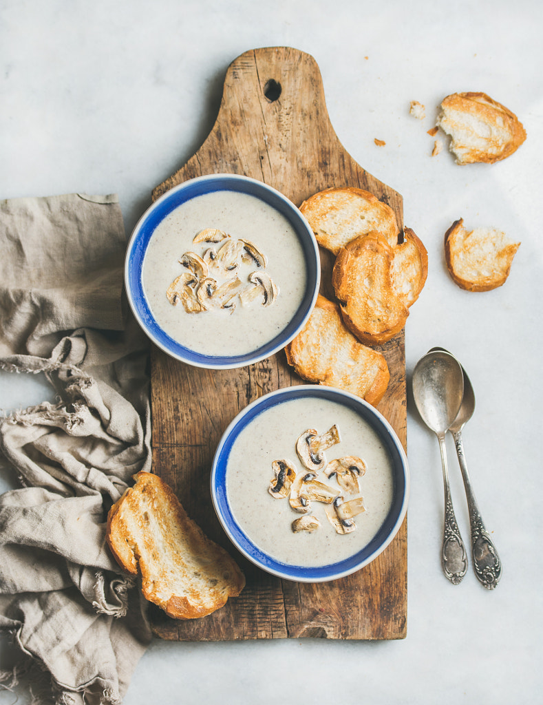 Creamy mushroom soup in bowls with toasted bread, marble background by Anna Ivanova on 500px.com