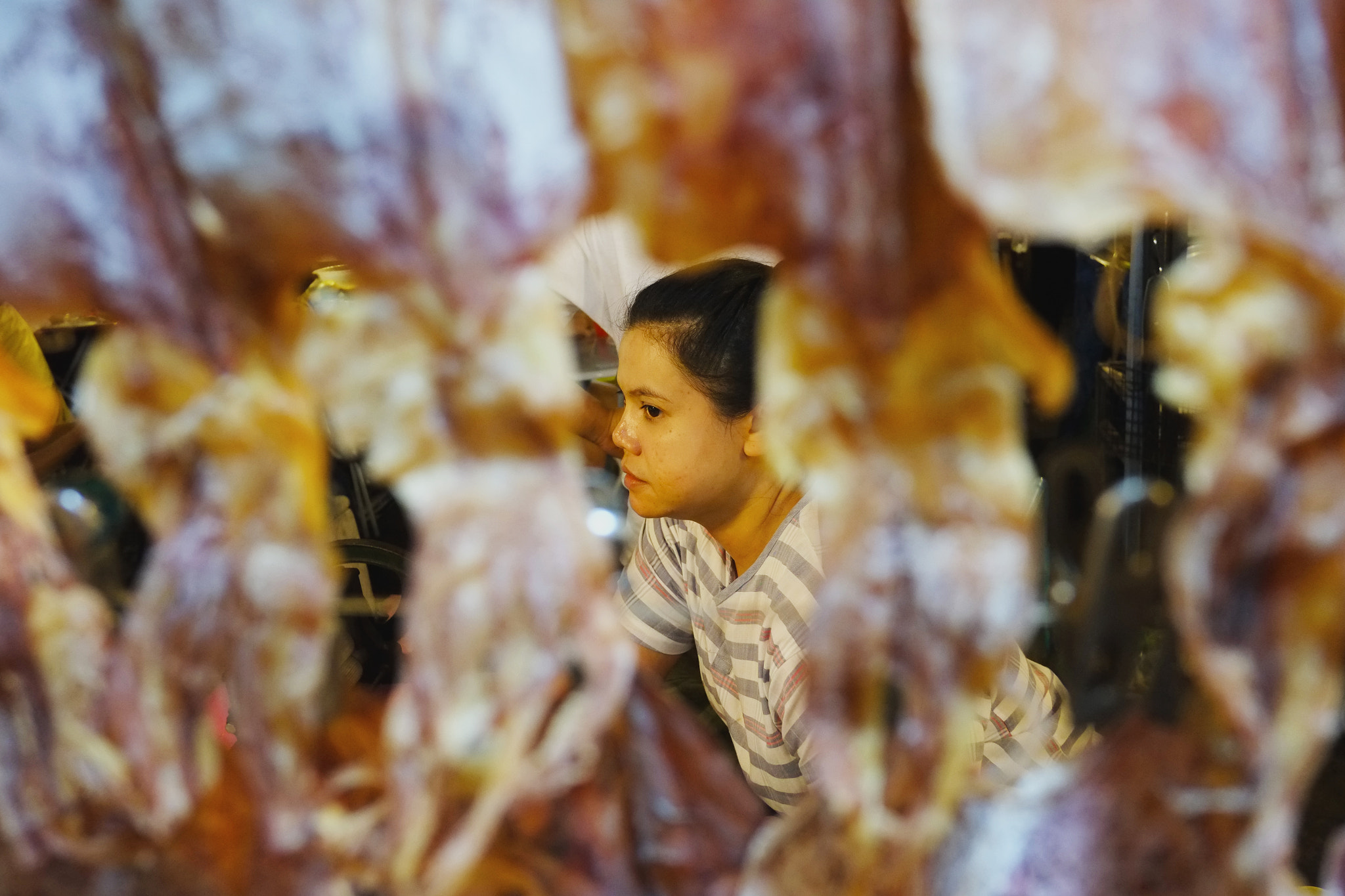 Fujifilm X-E1 sample photo. Woman behind the barbecue squids photography