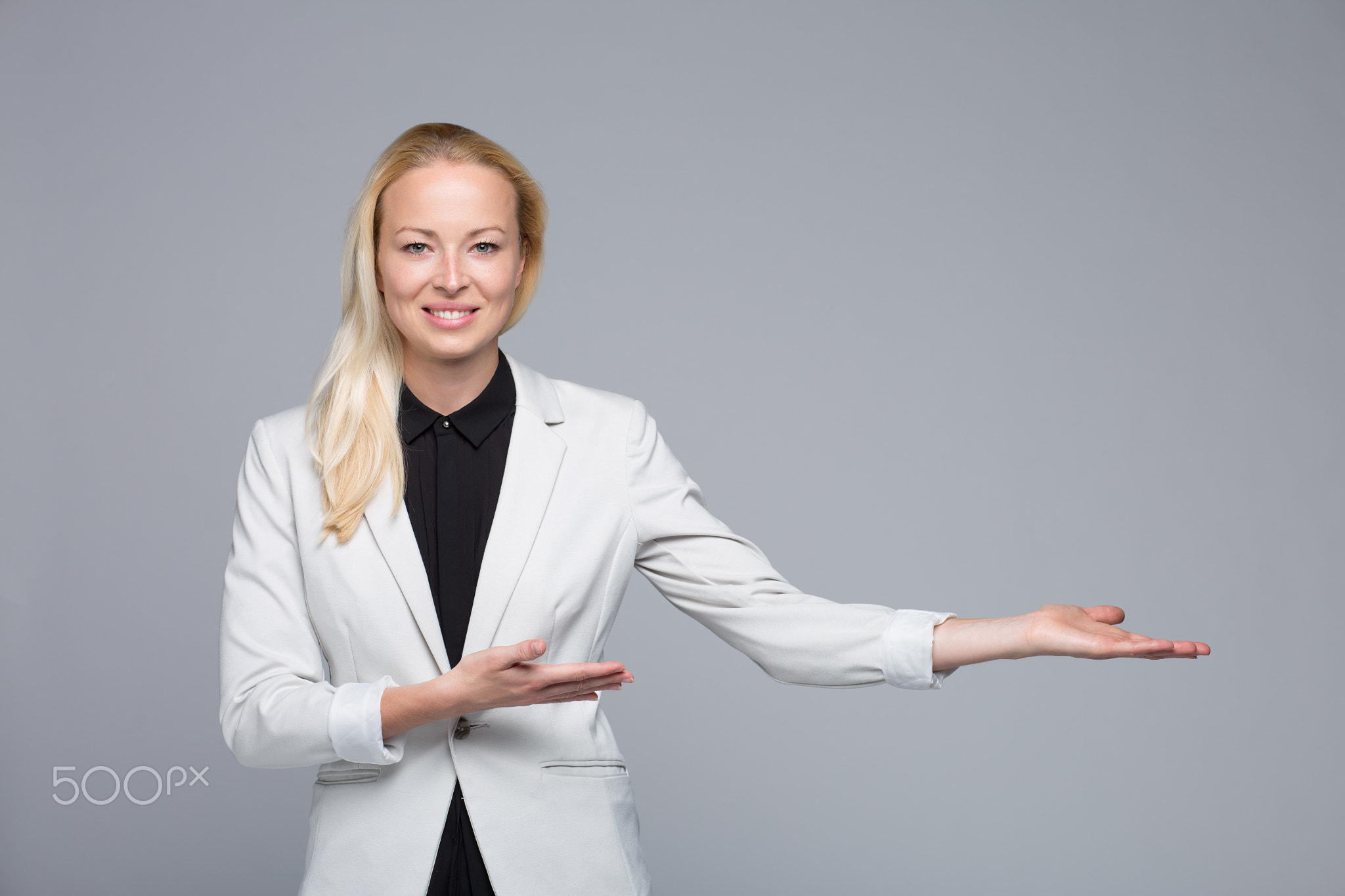 Business woman showing hand sign to side.