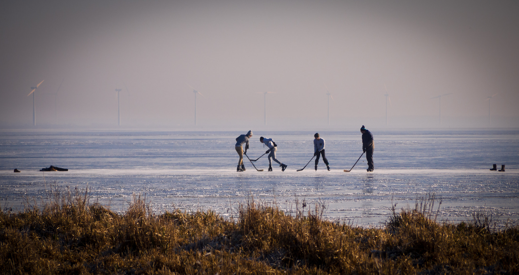 Panasonic Lumix G Vario 45-200mm F4-5.6 OIS sample photo. Boys playing ice hockey on the frozen eemmeer photography