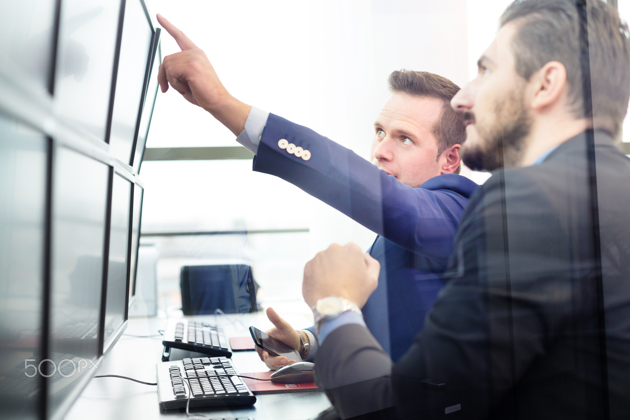 Stock traders looking at computer screens.