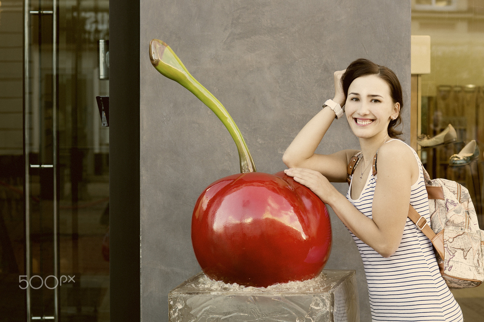 Sony SLT-A58 sample photo. Beautiful girl with a backpack leaning on huge artificial cherries photography