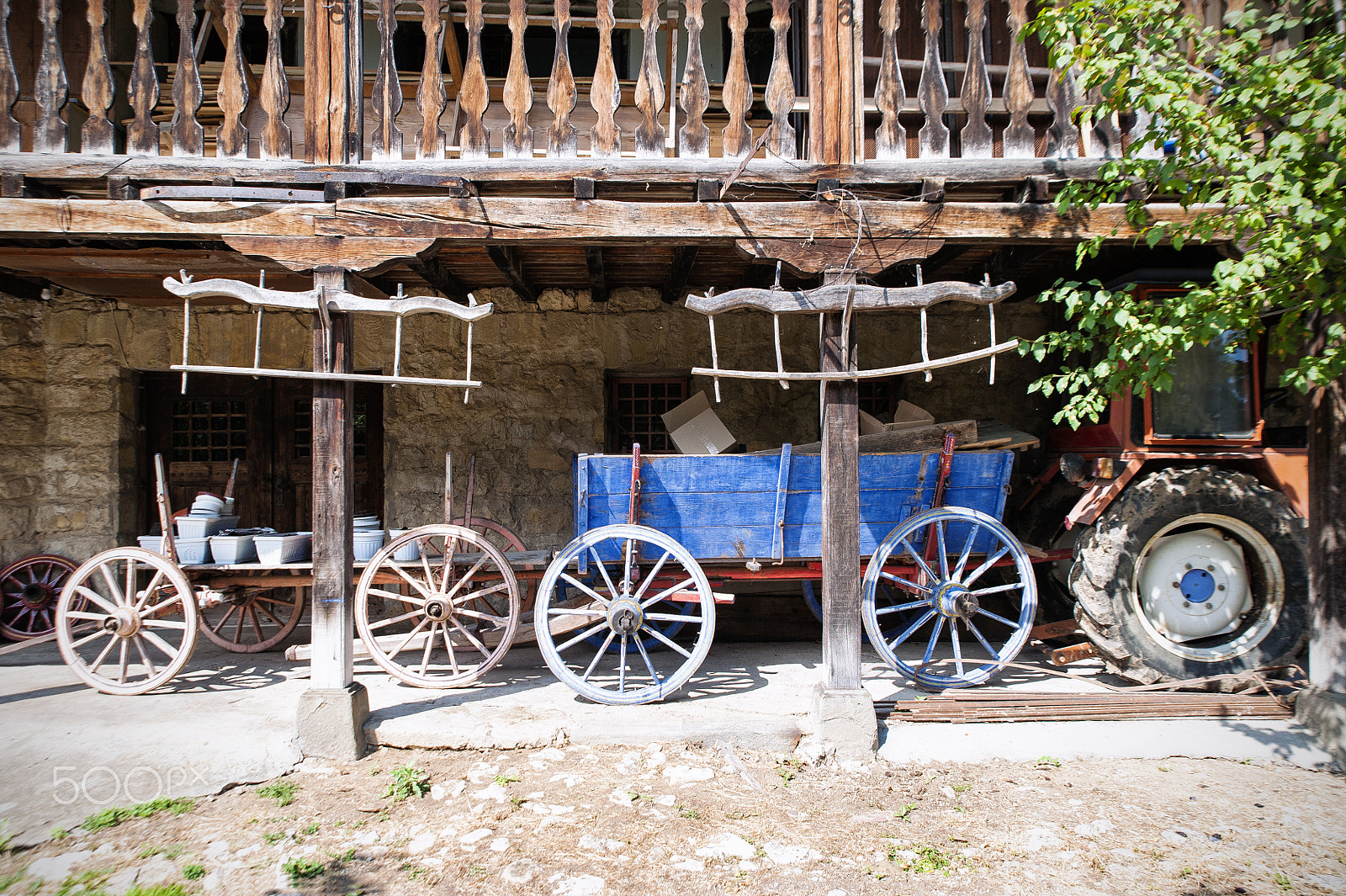 Nikon D700 + Tamron SP 24-70mm F2.8 Di VC USD sample photo. Two wagons and a tractor under a wooden balcony. photography
