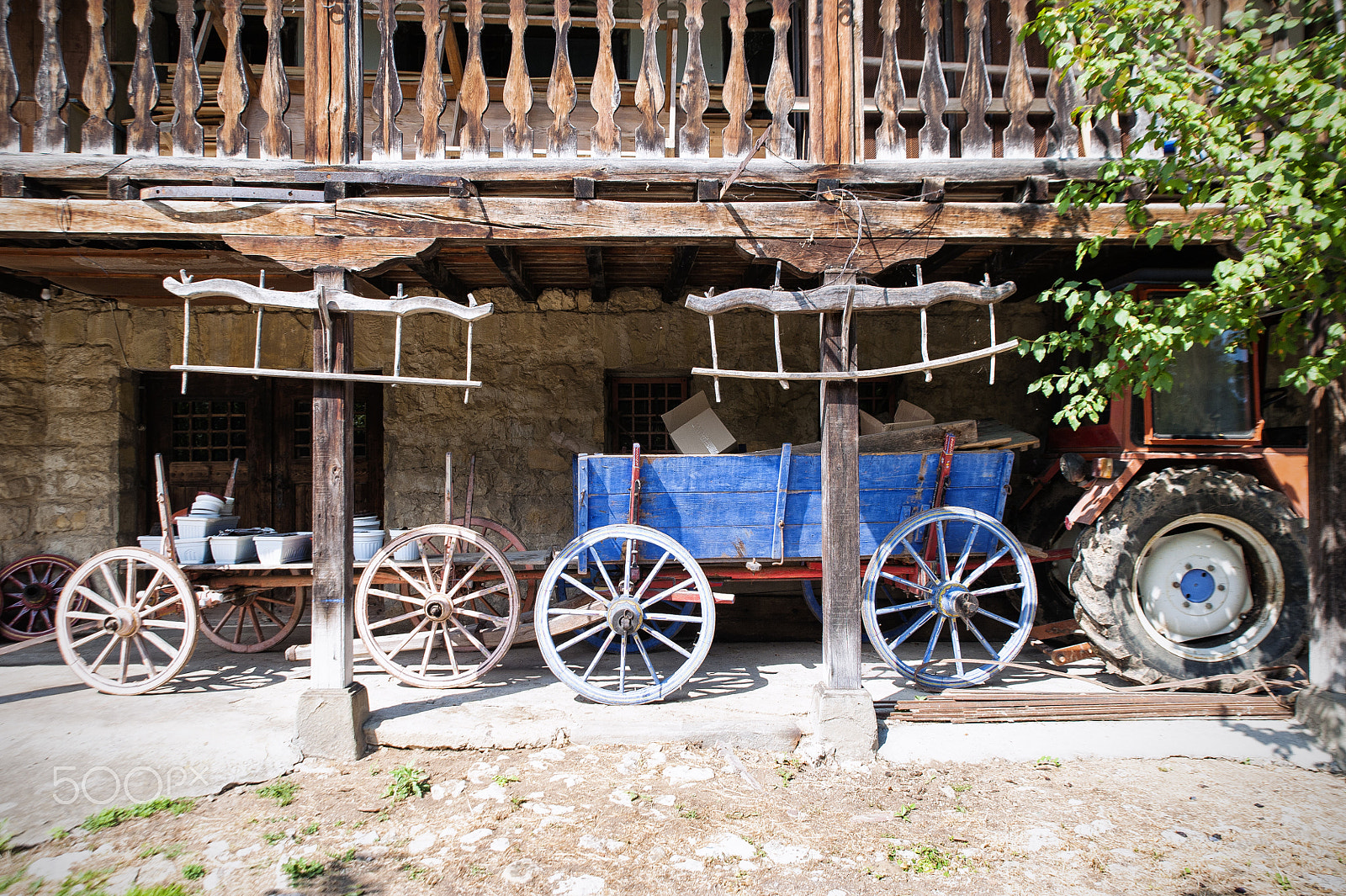 Tamron SP 24-70mm F2.8 Di VC USD sample photo. Two wagons and a tractor under a wooden balcony. photography