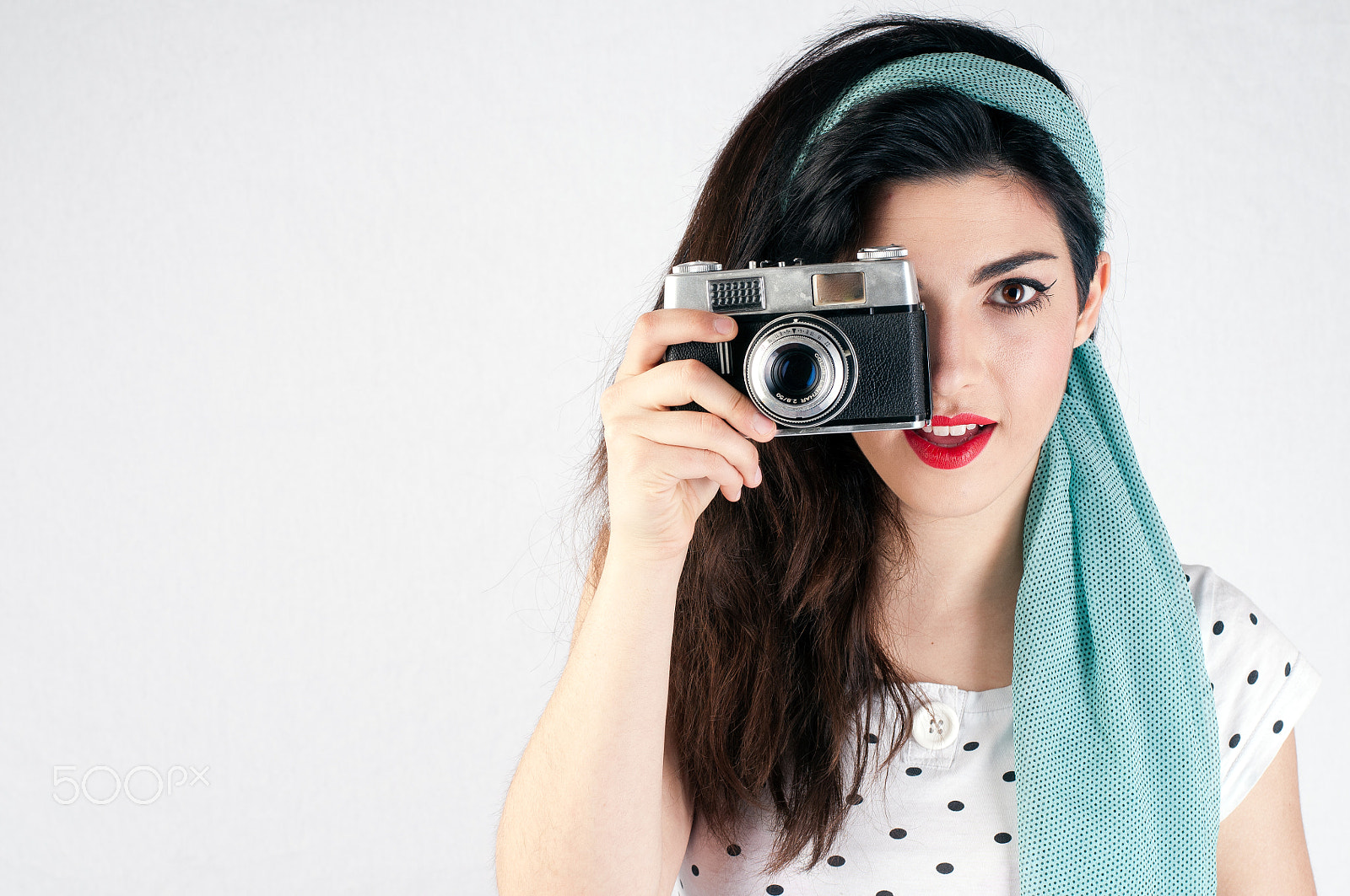 Nikon D300S + Nikon AF-S Nikkor 50mm F1.8G sample photo. Pinup style girl with red lips on a white background is holding photography