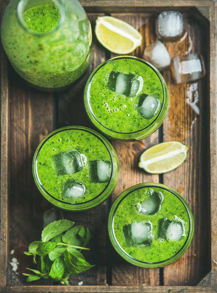 Fresh smoothie with ice cubes, mint, lime in wooden tray by Anna Ivanova on 500px.com