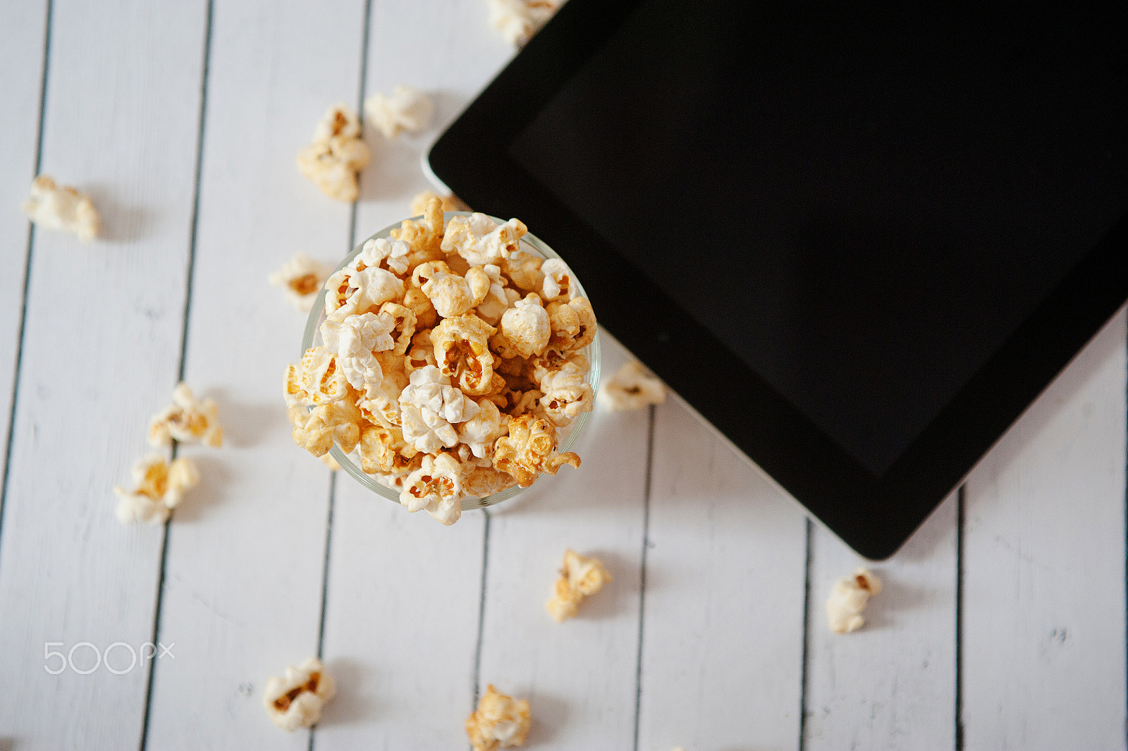 Nikon D700 + Sigma 24-70mm F2.8 EX DG Macro sample photo. Black tablet touch computer gadget with popcorn on white wooden background. photography