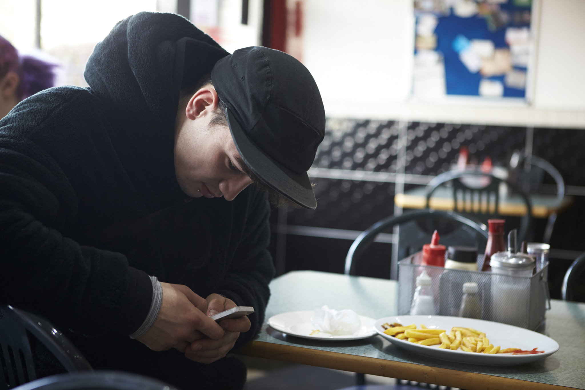 Canon EOS-1D X sample photo. Male student in café checking message on mobile phone photography