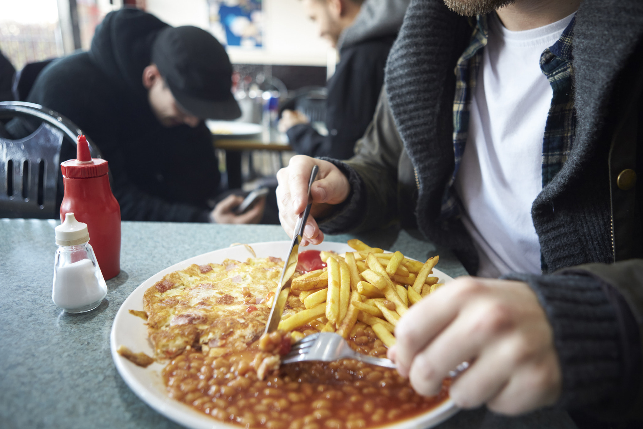 Canon EOS-1D X sample photo. Close up of male student eating meal in café photography