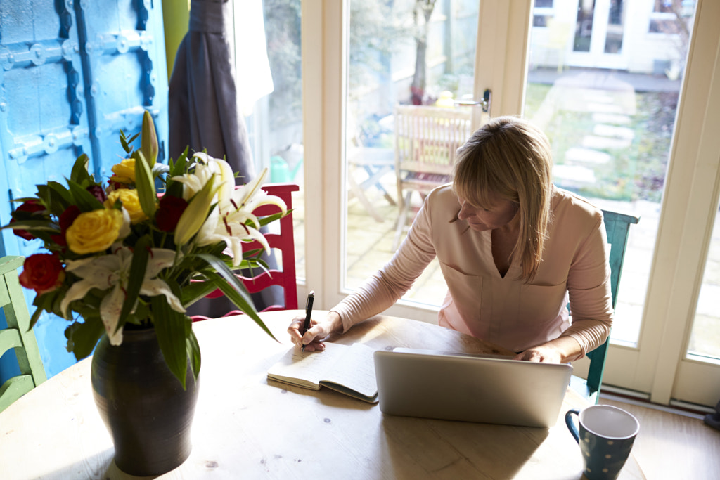 Woman Using Laptop At Dining Table Of Stylish Apartment by Guerilla Images on 500px.com