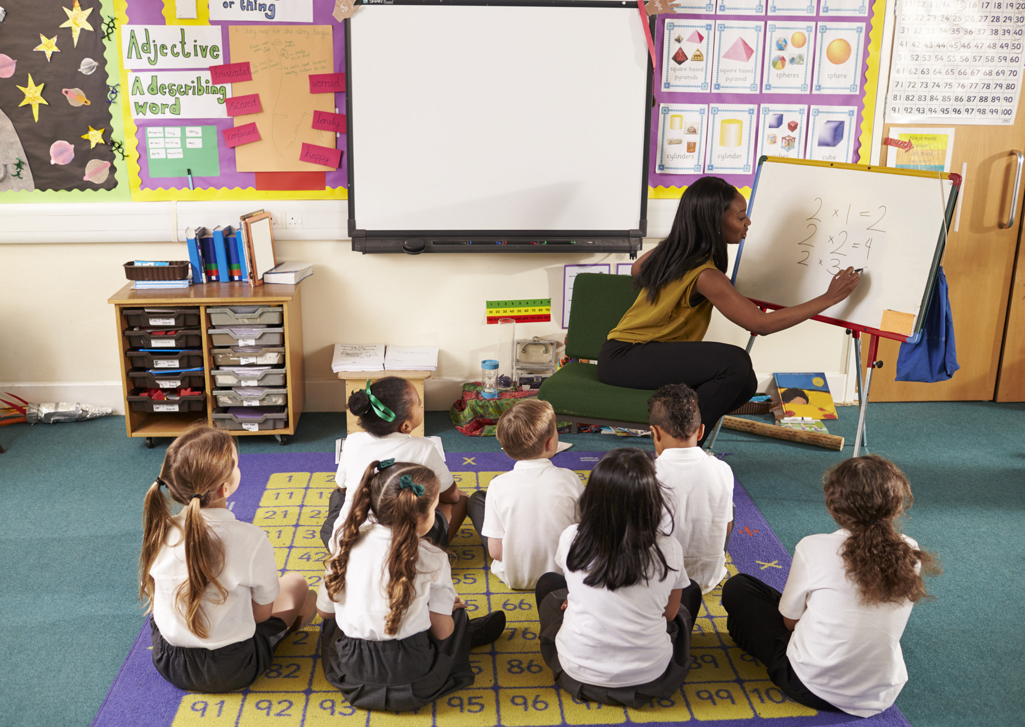 Teacher With Whiteboard In Elementary School Maths Class