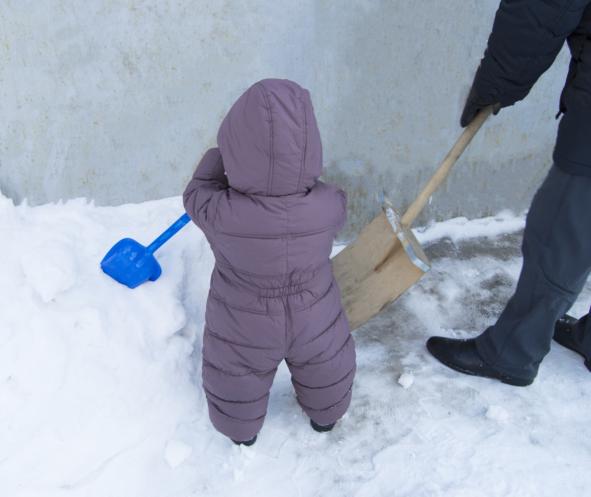 Father and baby together to clean up the snow shovels