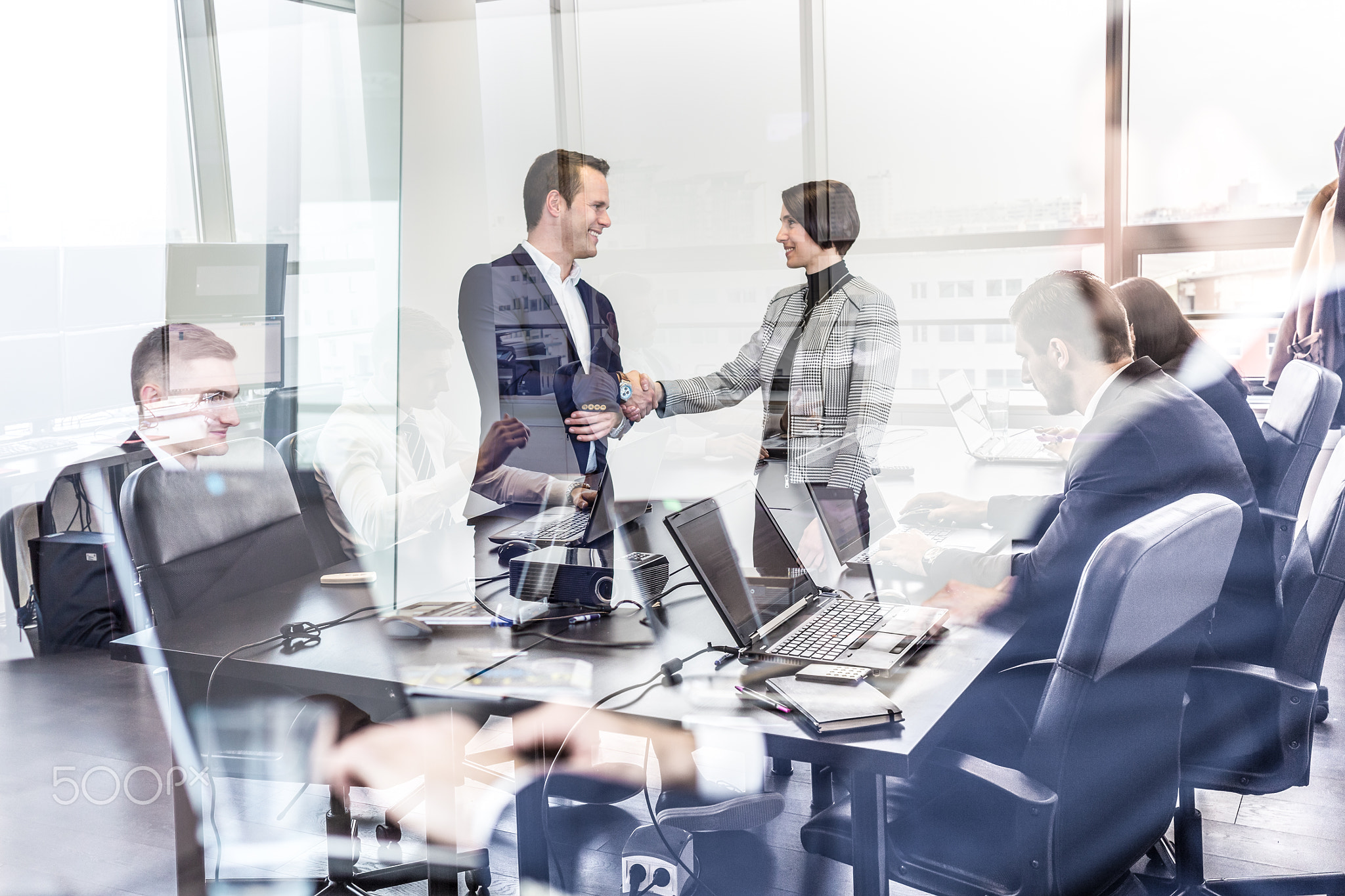 Business people shaking hands in moder corporate office.