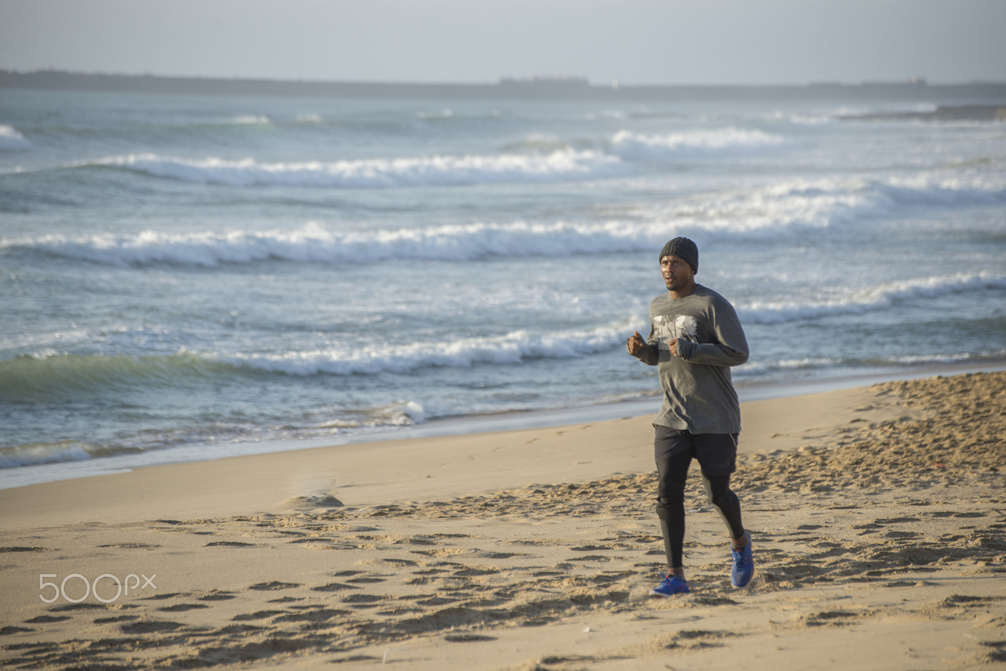 Man jogging on beach in early morning
