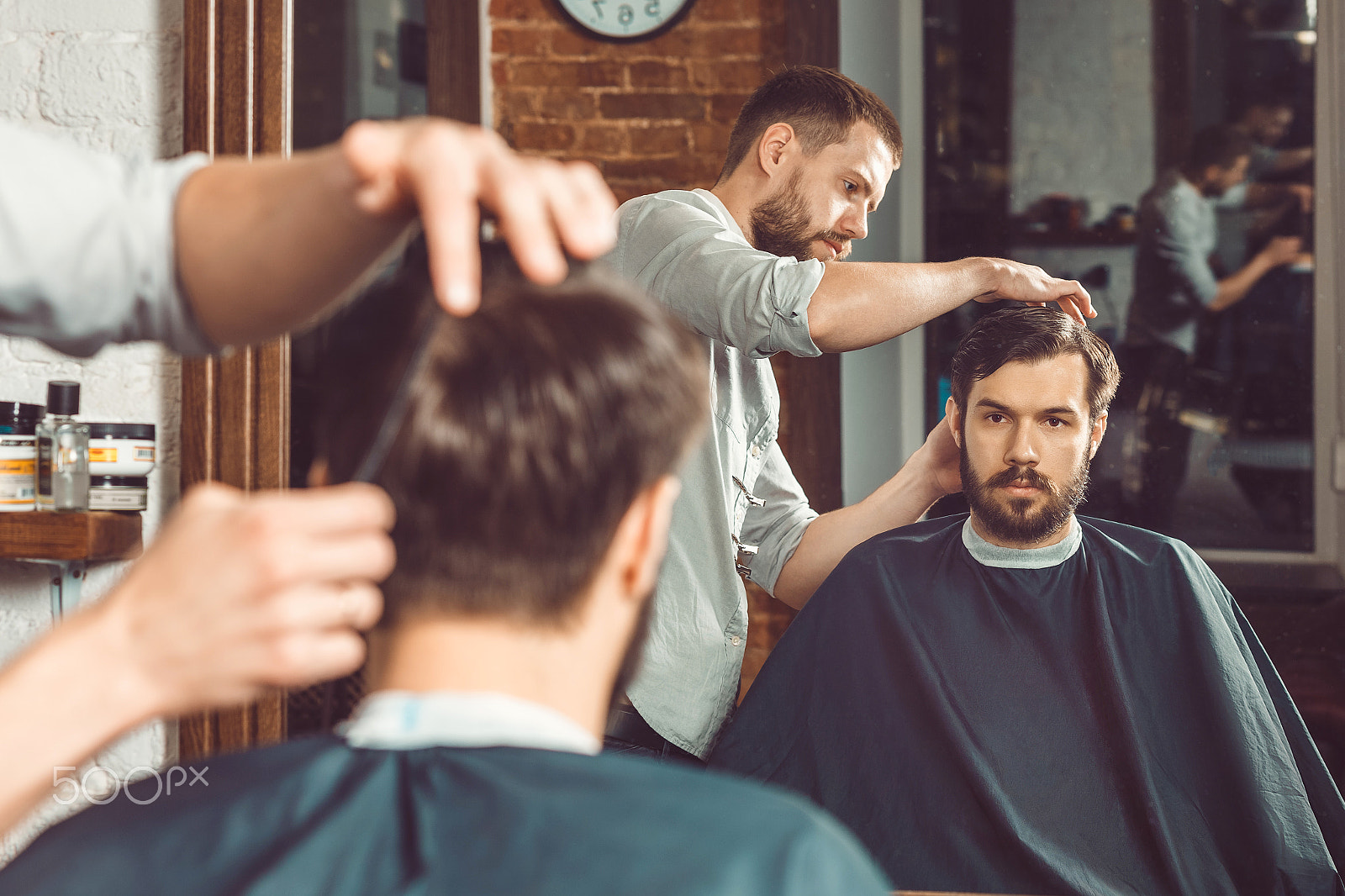 Canon EF 100mm F2.0 USM sample photo. Young handsome barber making haircut of attractive man in barbershop photography