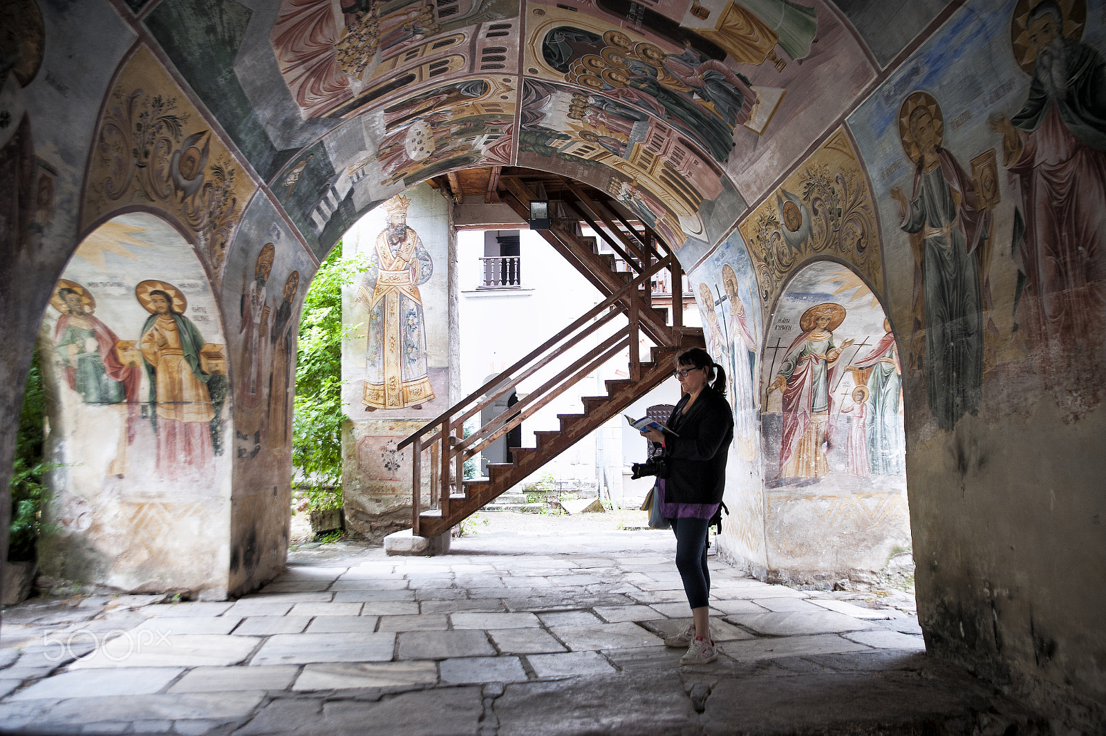 Tamron SP 24-70mm F2.8 Di VC USD sample photo. Tourist under polychrome arches of a monastery photography