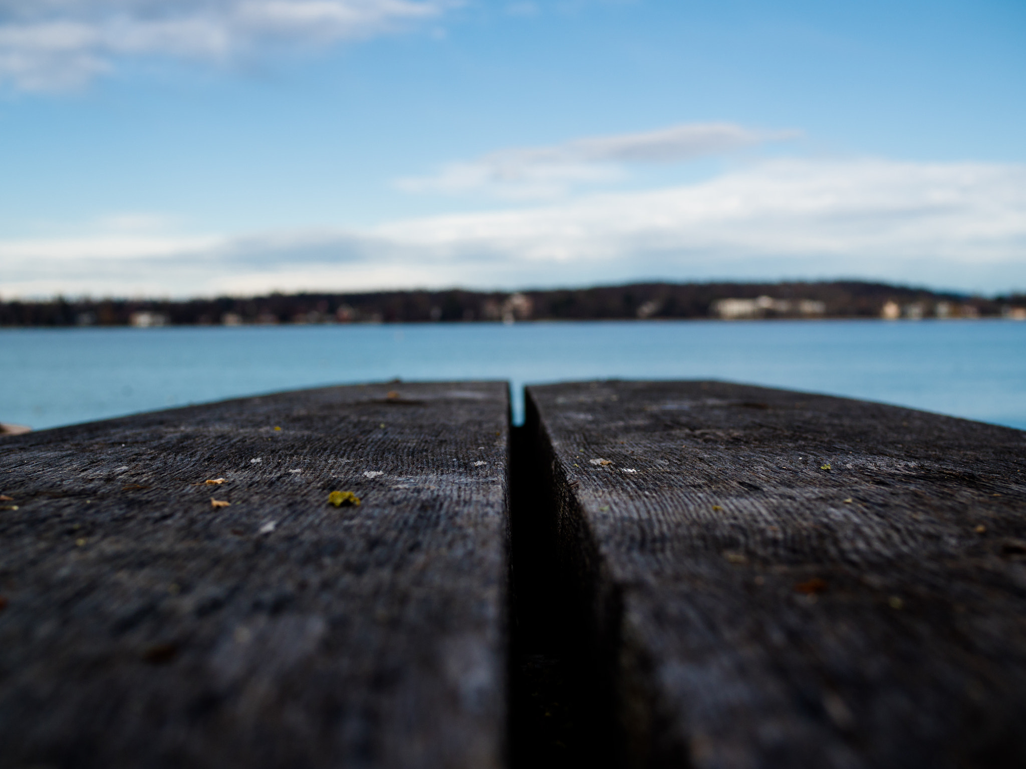 Olympus OM-D E-M5 II + Olympus M.Zuiko Digital 25mm F1.8 sample photo. Empty wooden table with view on the lake photography