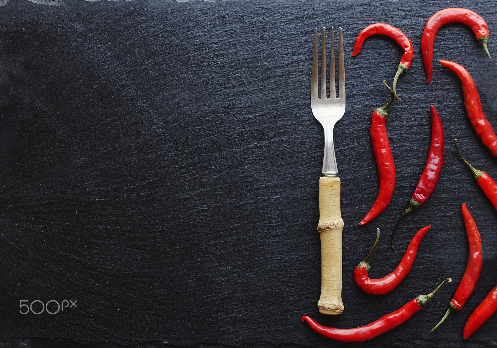 Nikon AF-S DX Micro Nikkor 40mm F2.8 sample photo. Red chili peppers on a wooden table with a fork, concept, top view photography