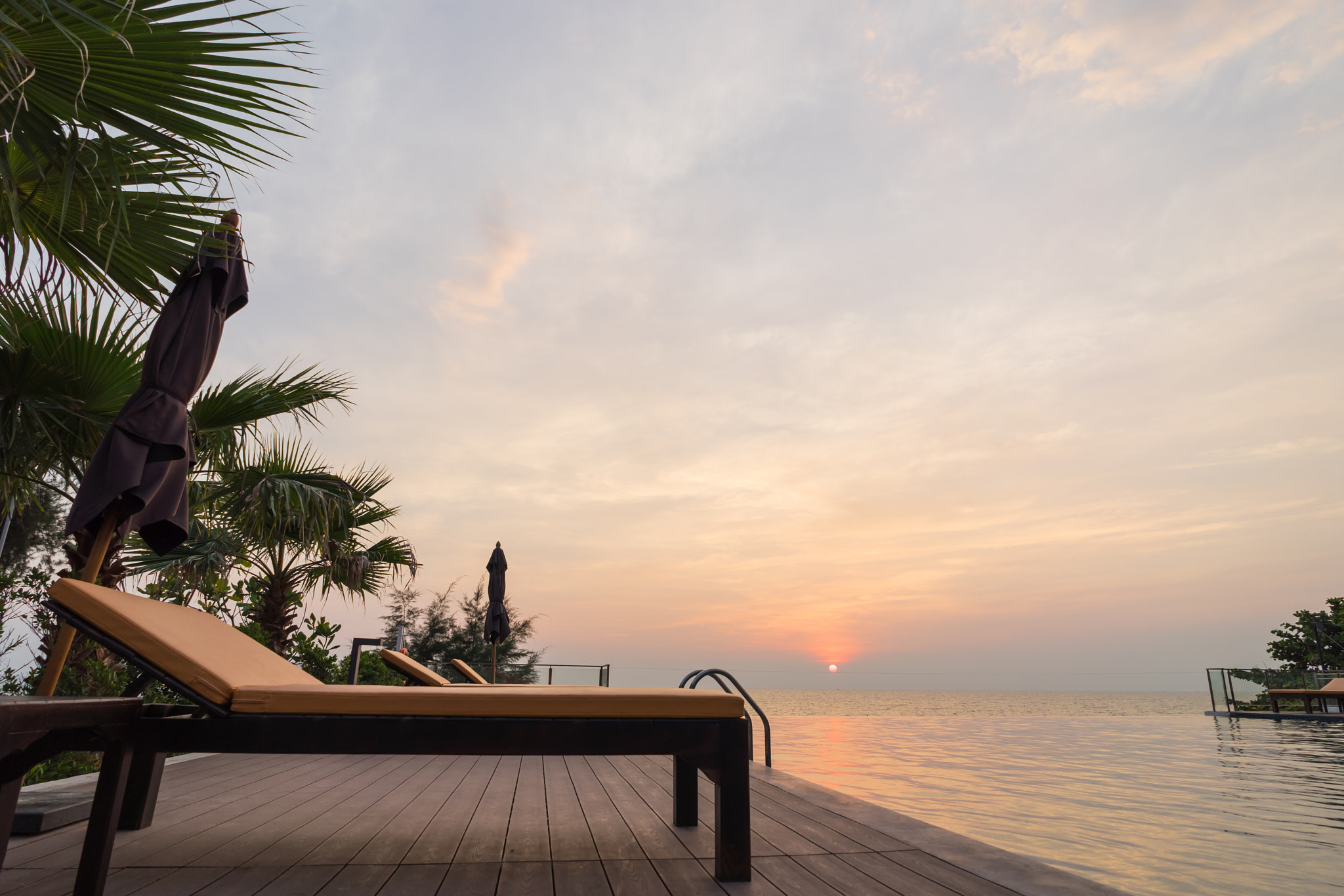 Sony a7 II + FE 21mm F2.8 sample photo. Swimming pool in the backyard and sunbed with sunset scene backg photography