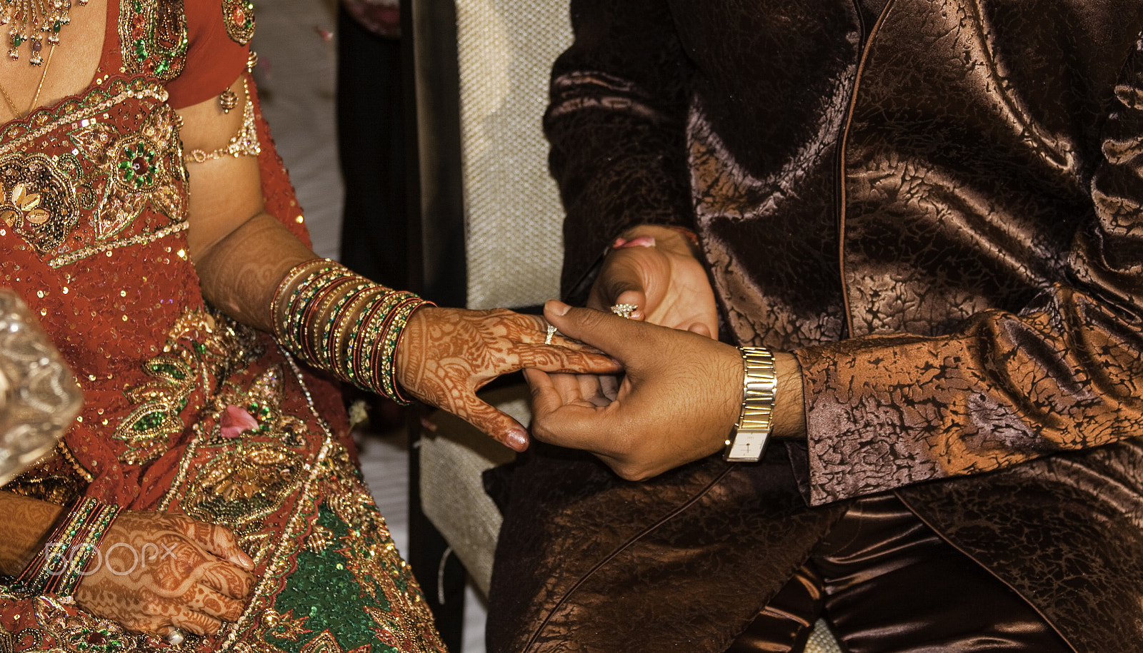 Canon EF 28-135mm F3.5-5.6 IS USM sample photo. Man putting a gold ring on the henna patterned hand of a lady du photography
