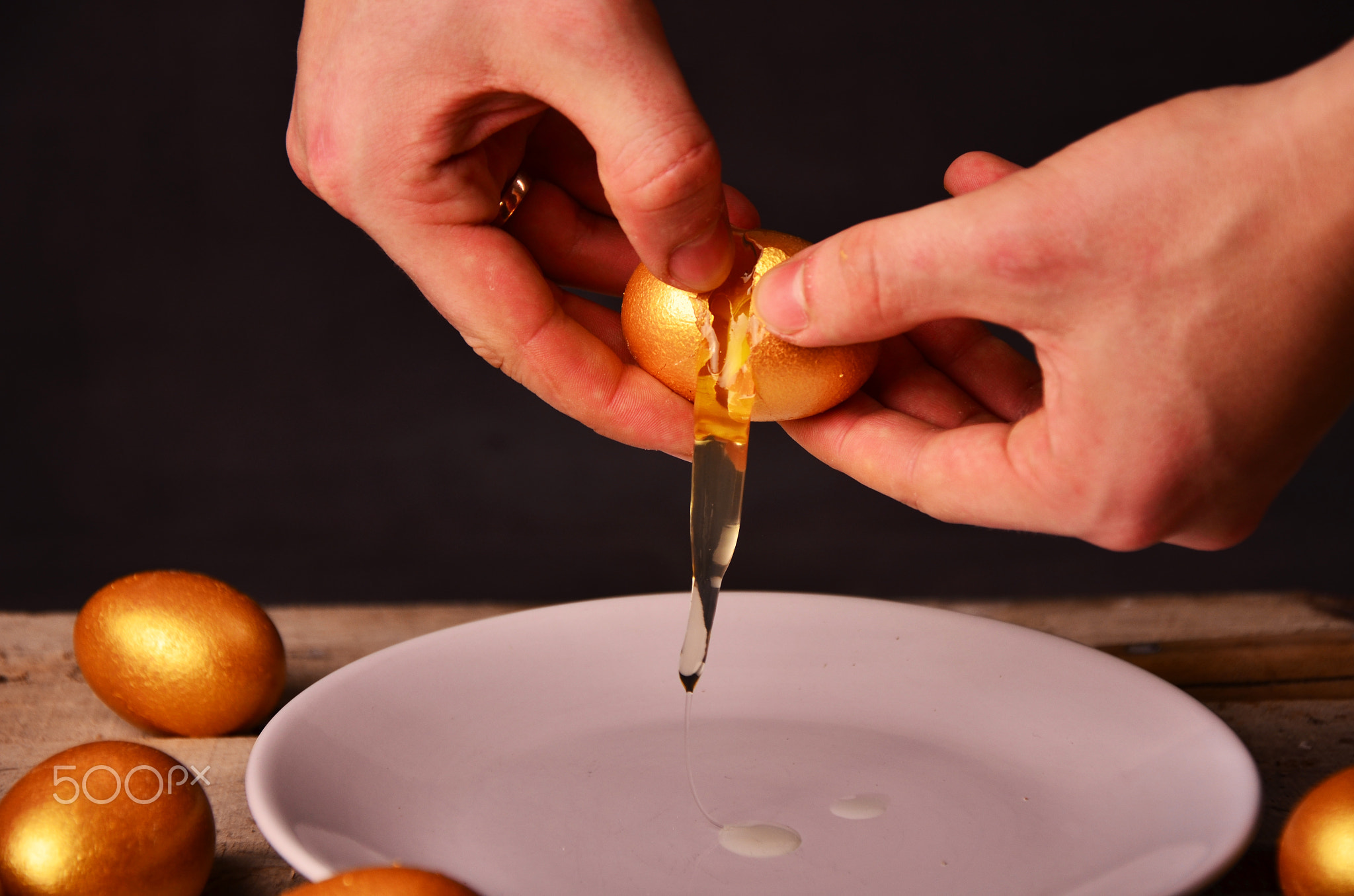 to smash the Golden egg on wooden background